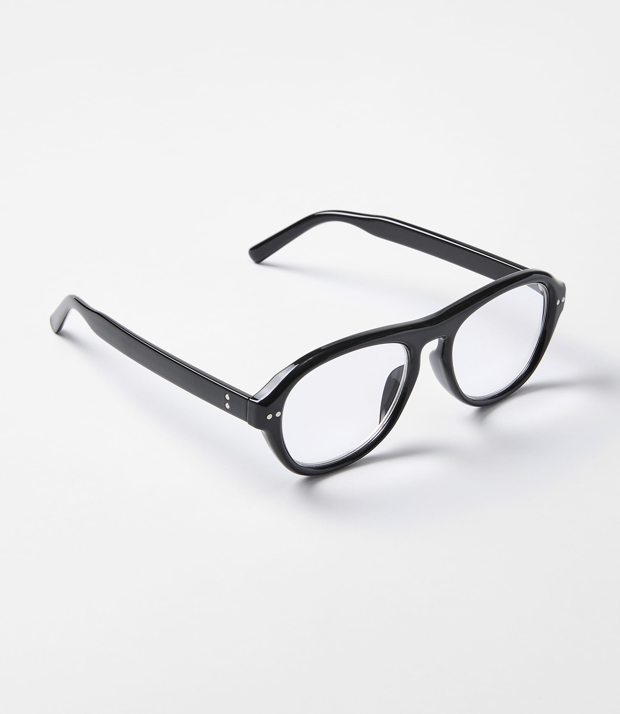 Black-rimmed glasses with clear lenses rest on a plain white surface.