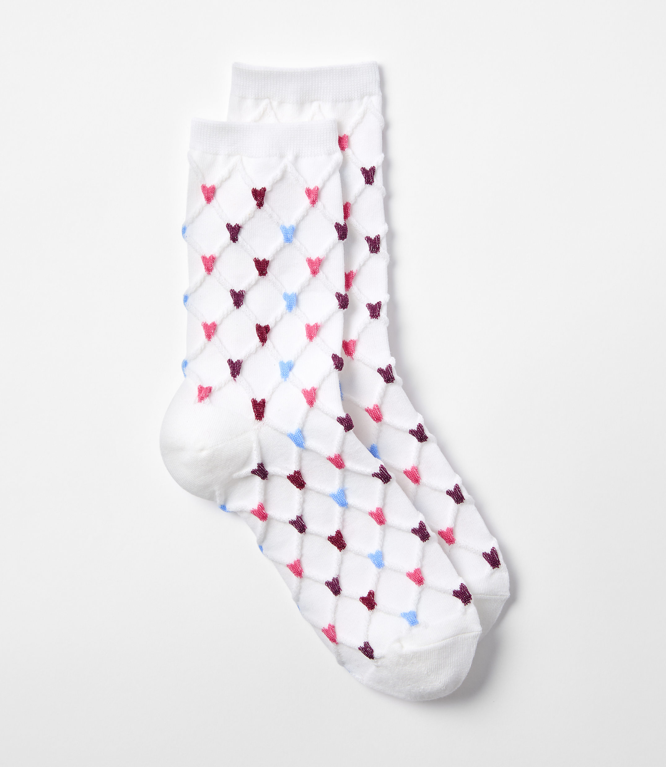 A pair of white socks with a diamond pattern of pink, blue, and maroon hearts are laid out on a plain white background.