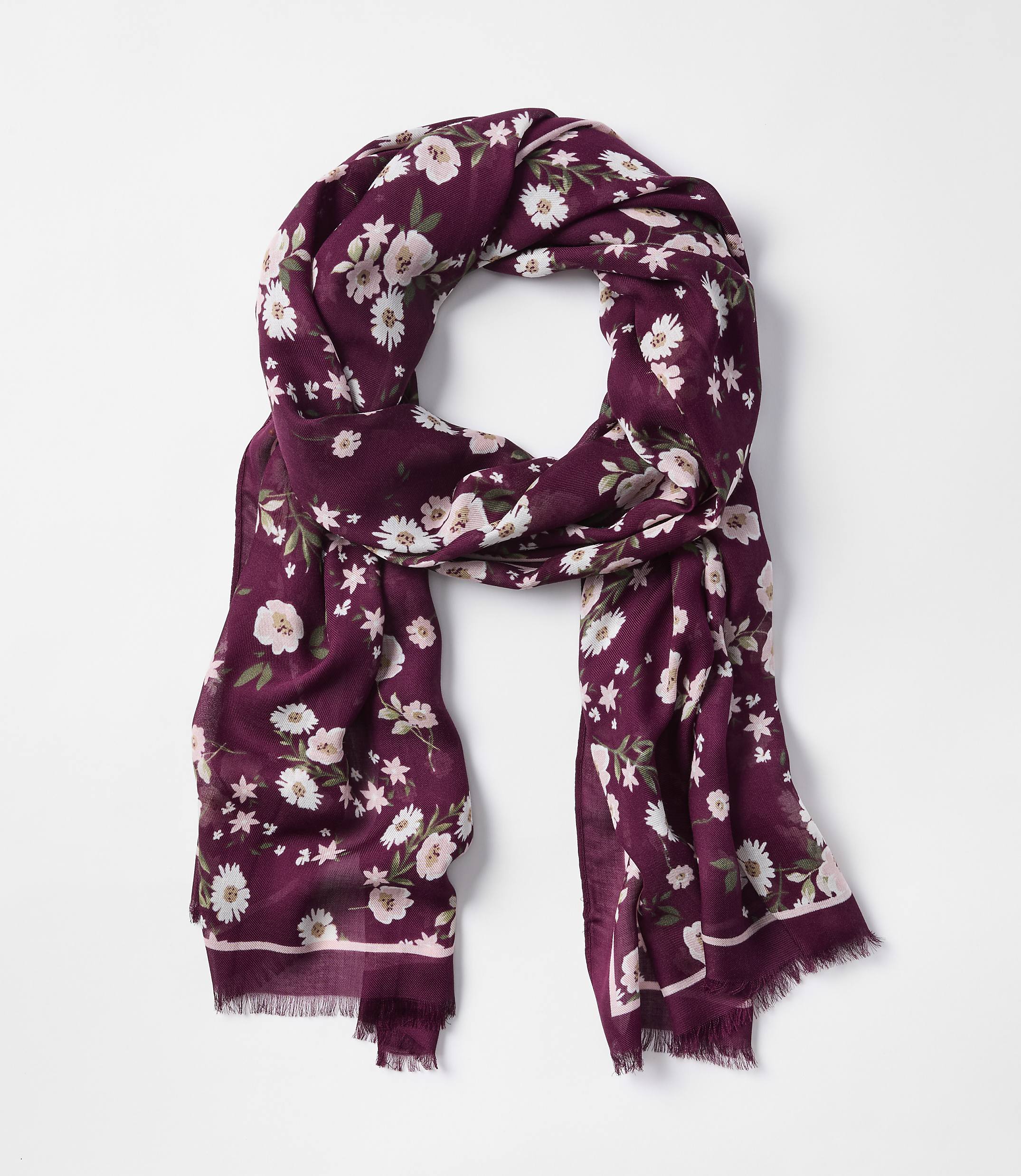 A burgundy floral scarf with frayed edges is laid out against a plain white background.