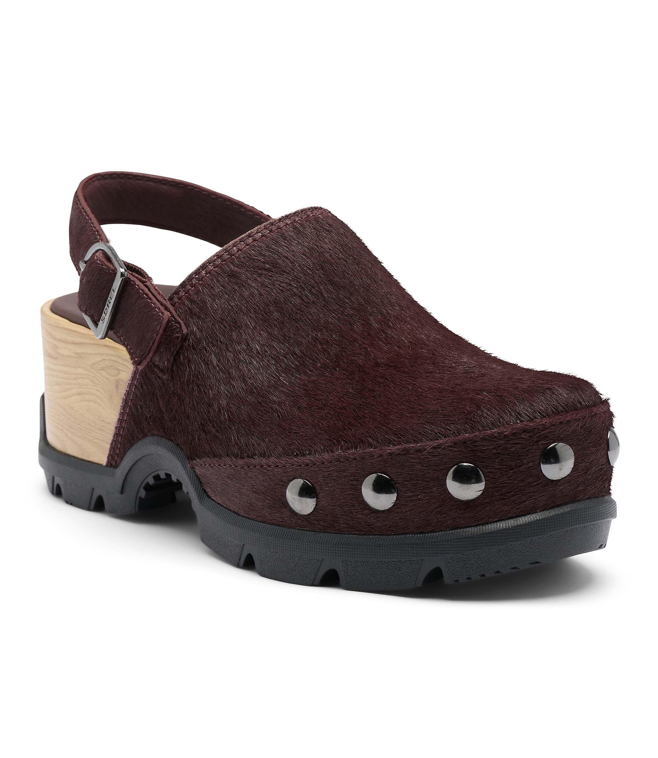 A burgundy, furry clog with a wooden heel and silver studs sits on a white background.