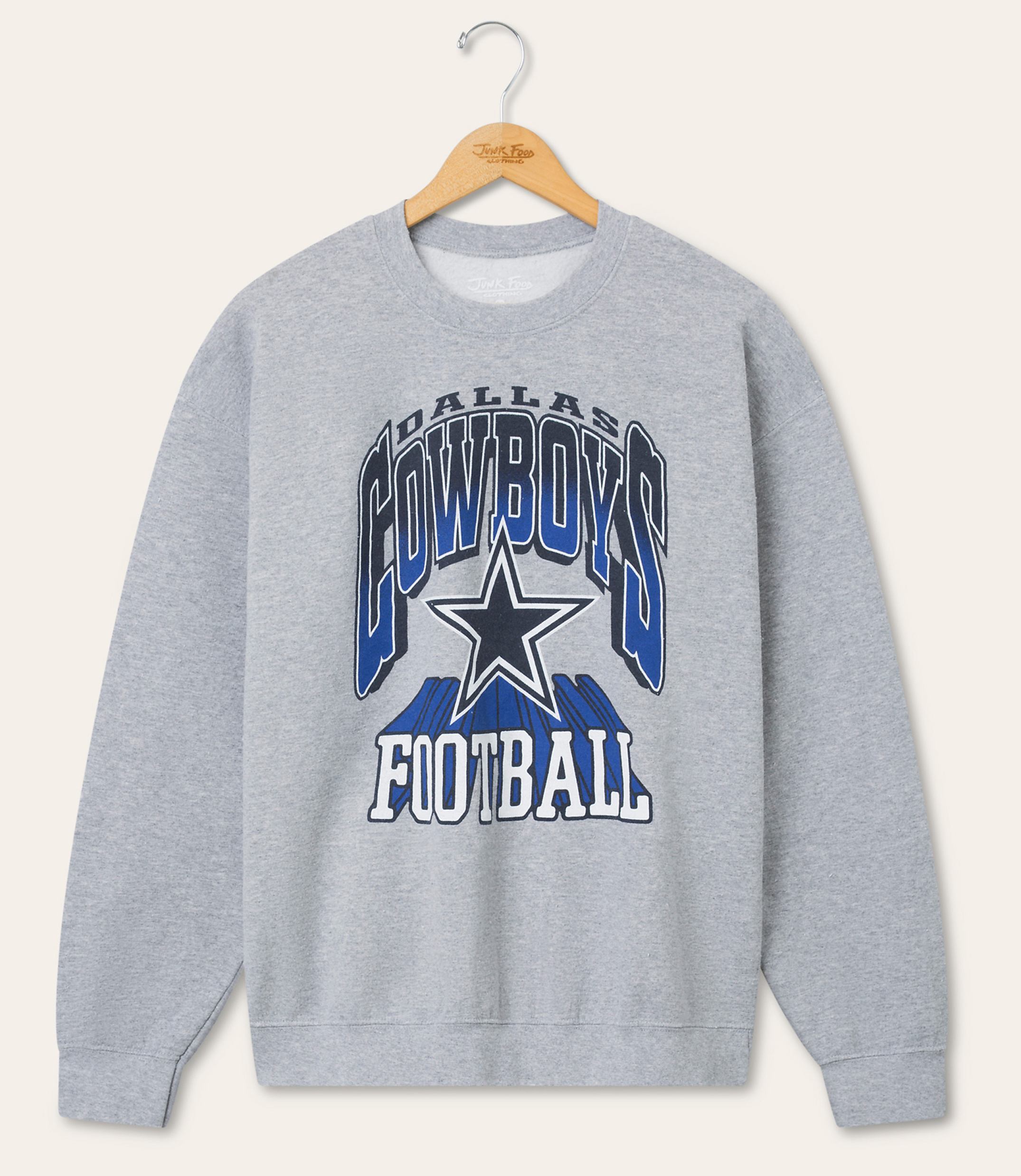 A gray Dallas Cowboys football sweatshirt hangs on a hanger against a plain, light-colored background.