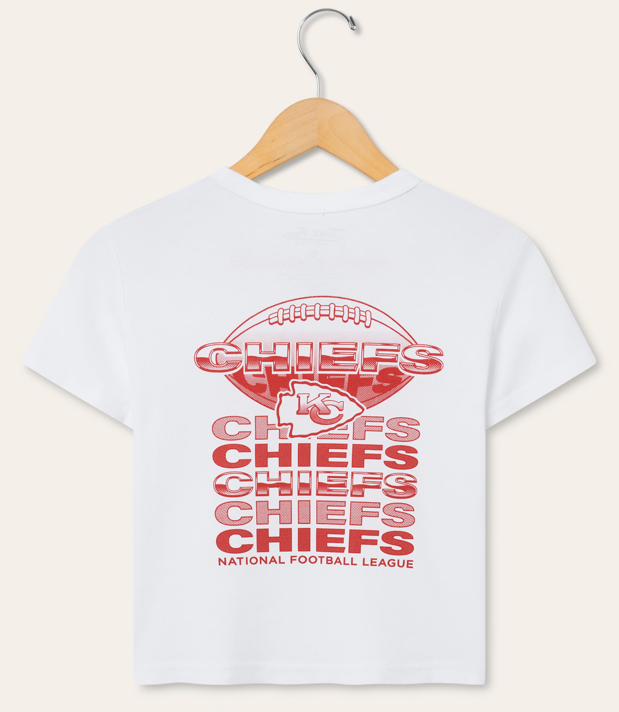 A white t-shirt with a red Kansas City Chiefs logo and repeated "Chiefs" text is displayed on a wooden hanger against a plain white background.