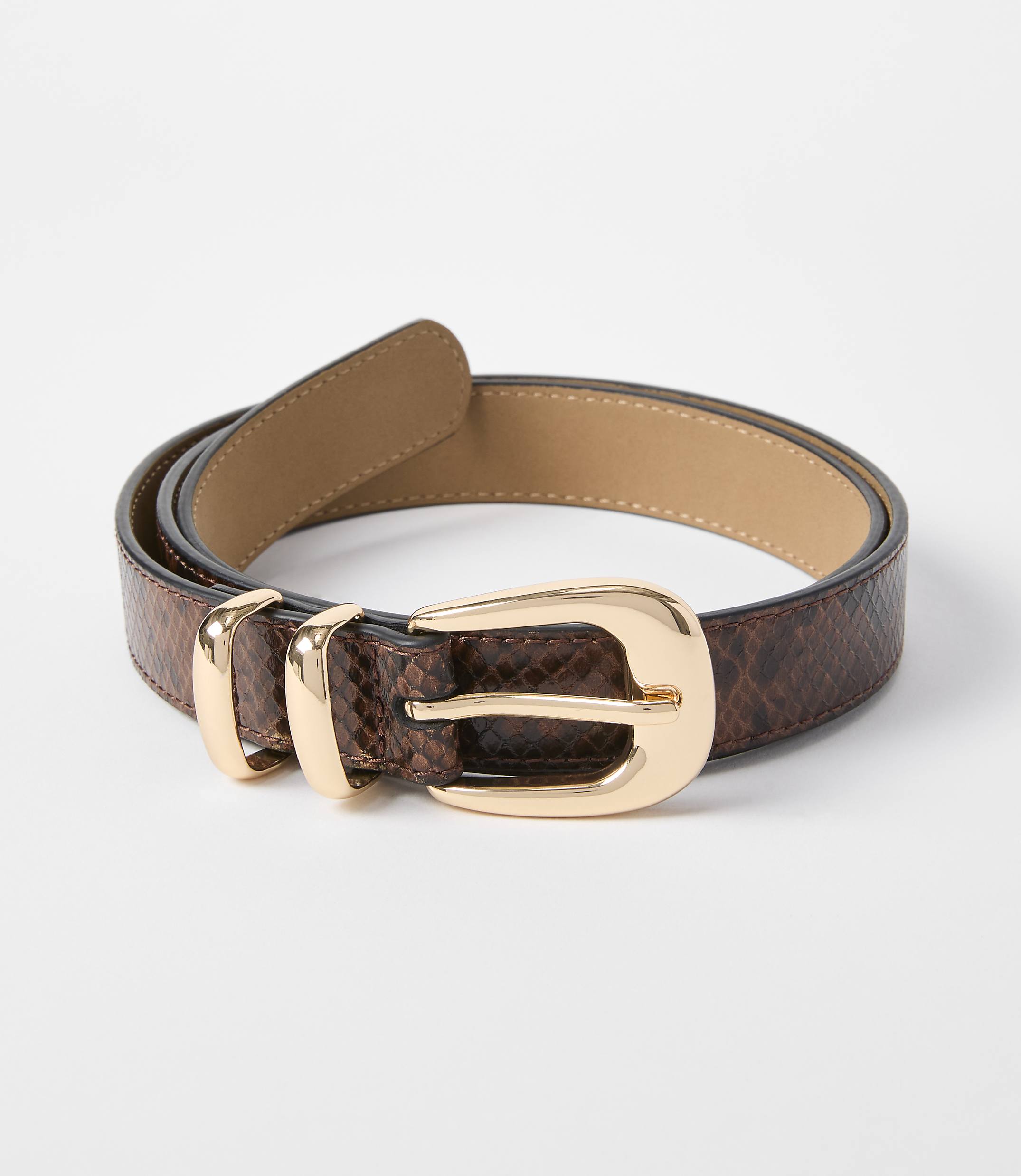 A brown snakeskin belt with a gold buckle lies on a white background.