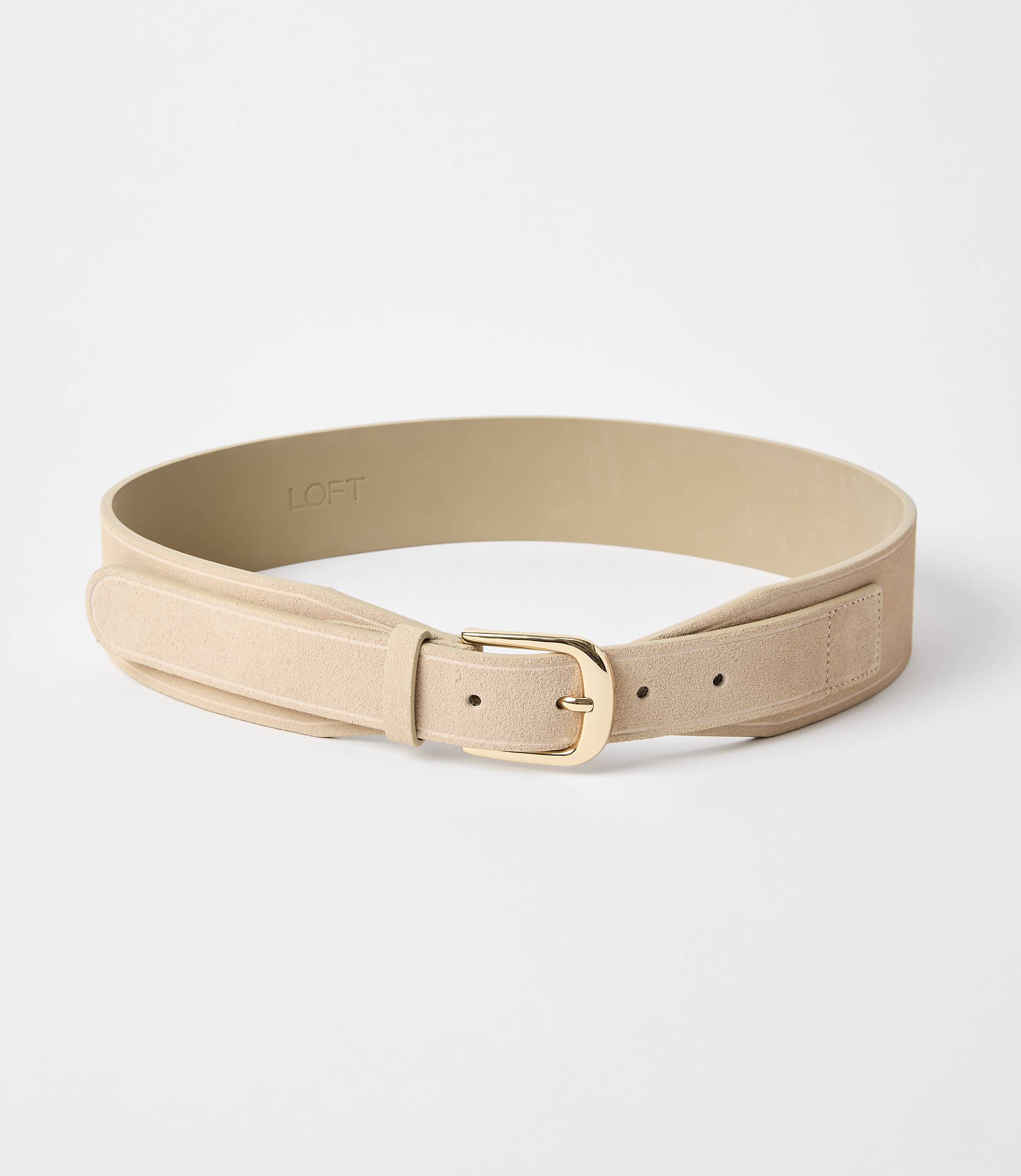 A light tan suede belt with a gold buckle lies on a plain white background.