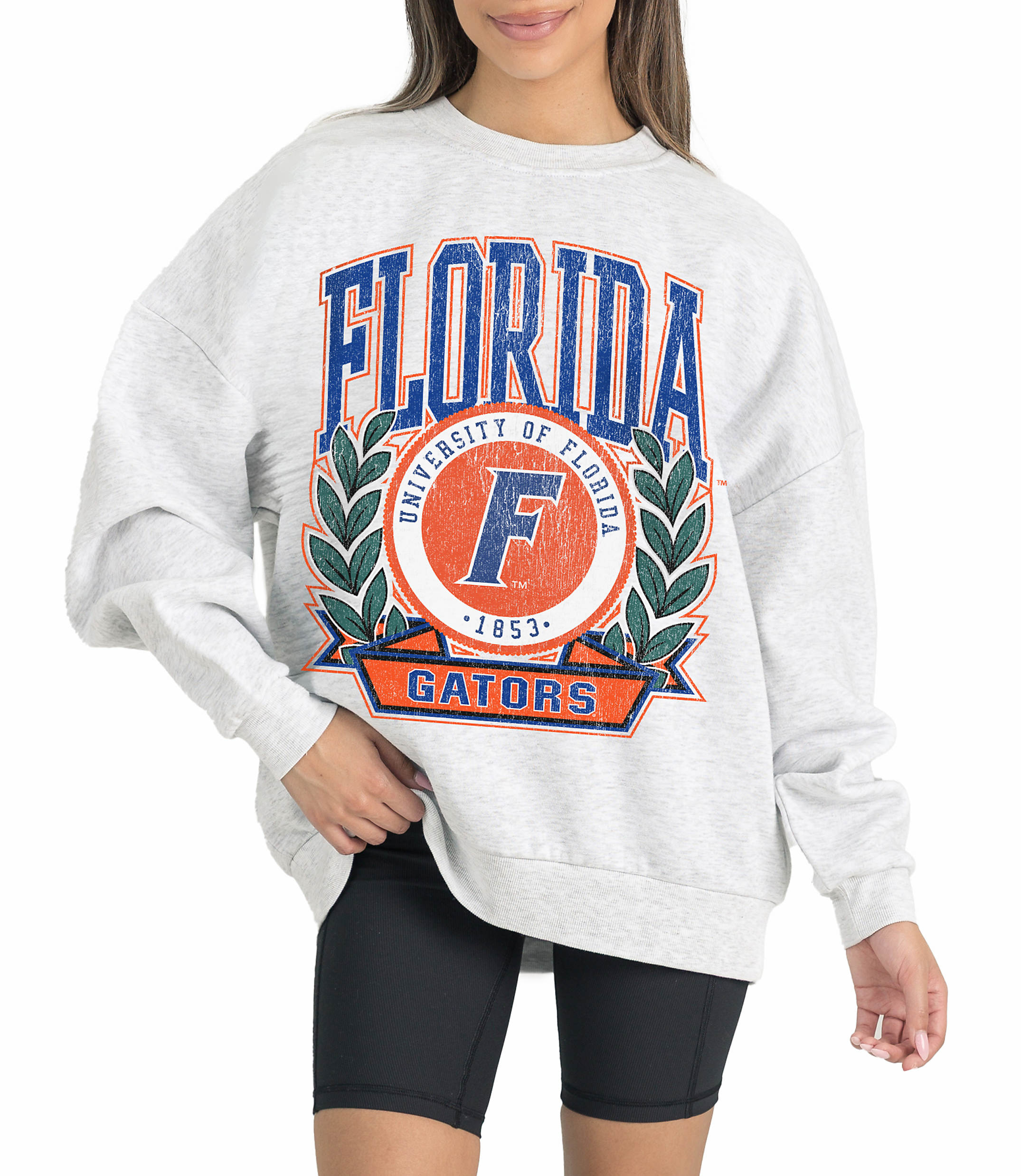 A woman in a grey sweatshirt with "Florida Gators" emblazoned on it stands against a white background.