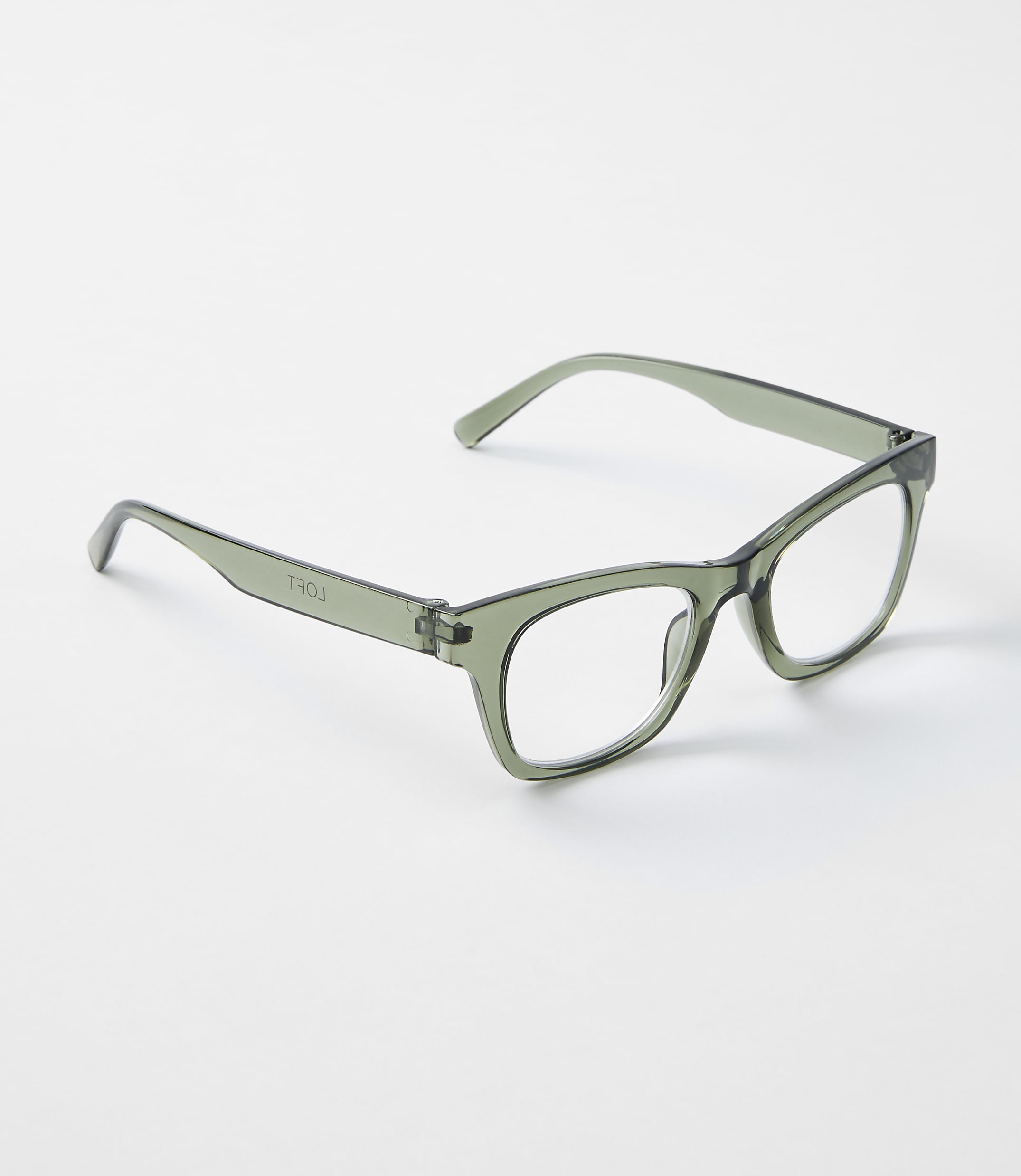A pair of translucent green glasses rests on a plain white background.