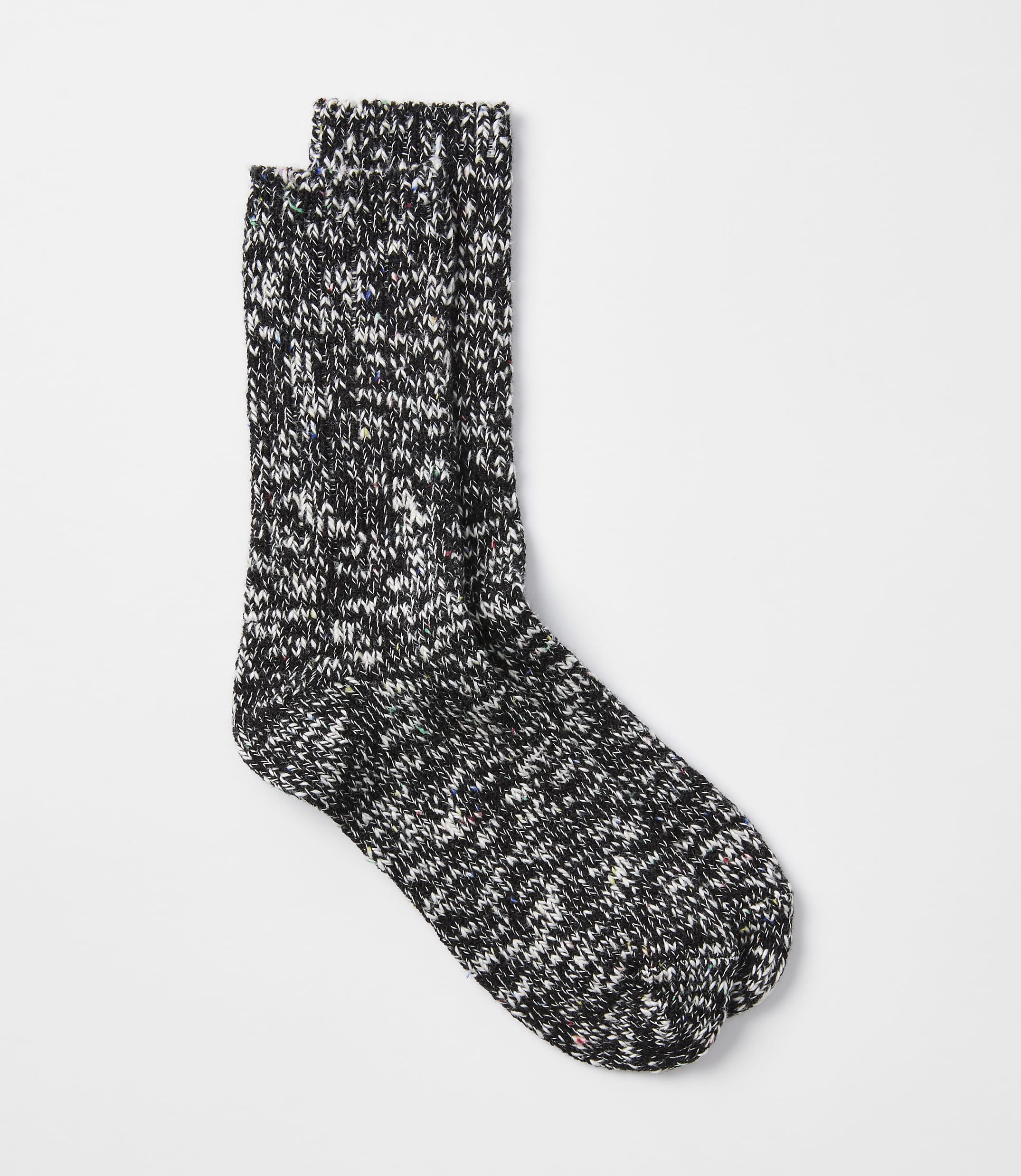 A pair of speckled black and white socks rests on a plain white background.