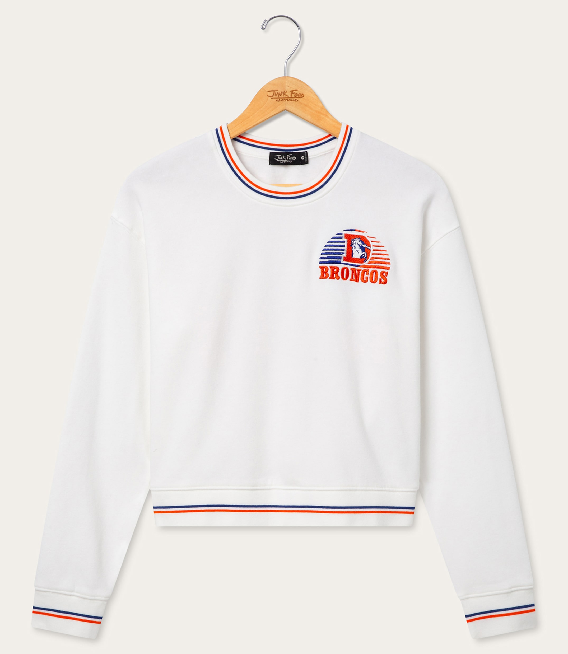 A white sweatshirt with a Denver Broncos logo is hanging on a wooden hanger against a plain white background.