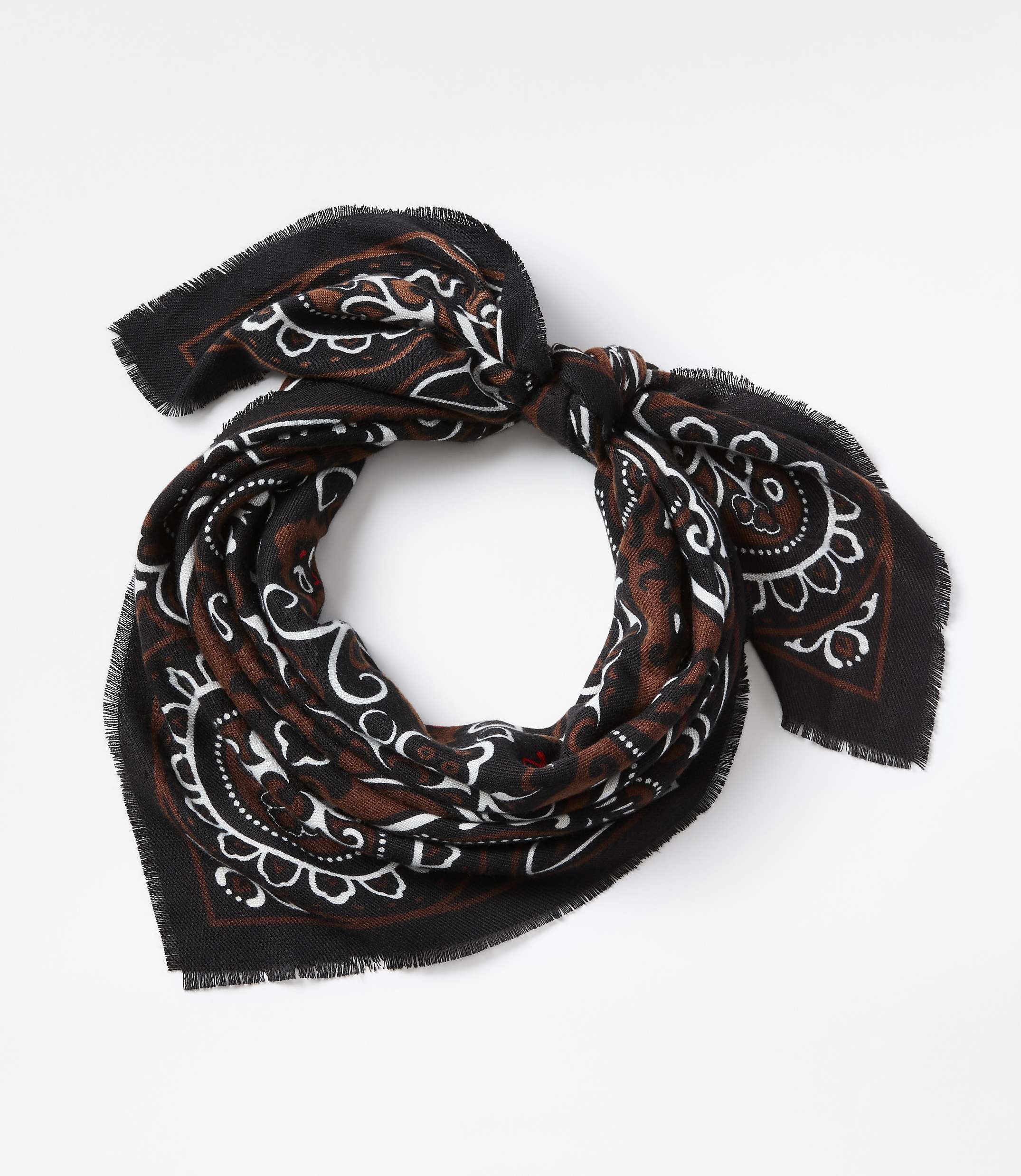 A black and brown paisley-patterned scarf with frayed edges is tied in a knot against a plain white background.