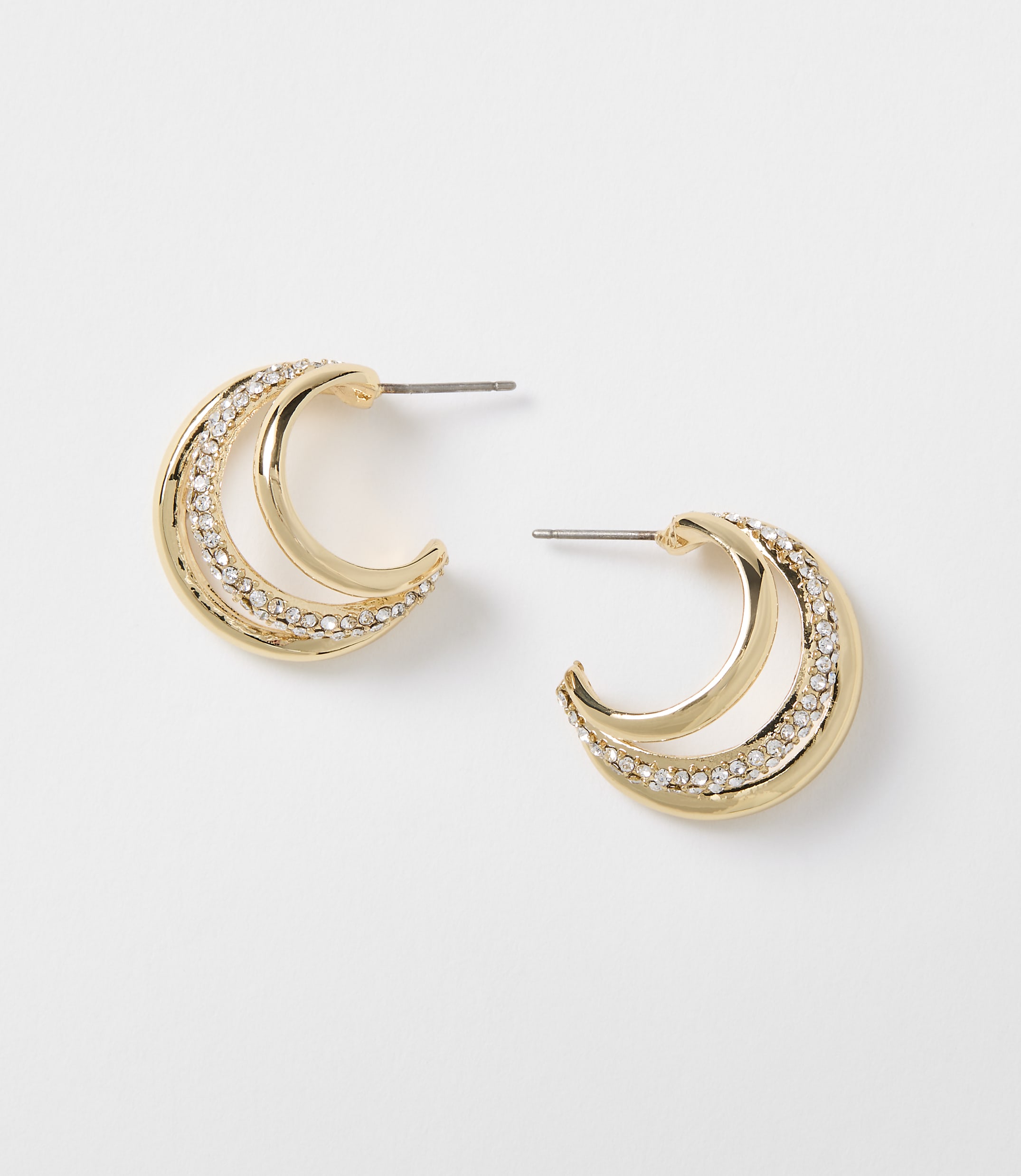 A pair of gold crescent-shaped earrings with clear rhinestones are displayed against a plain white background.