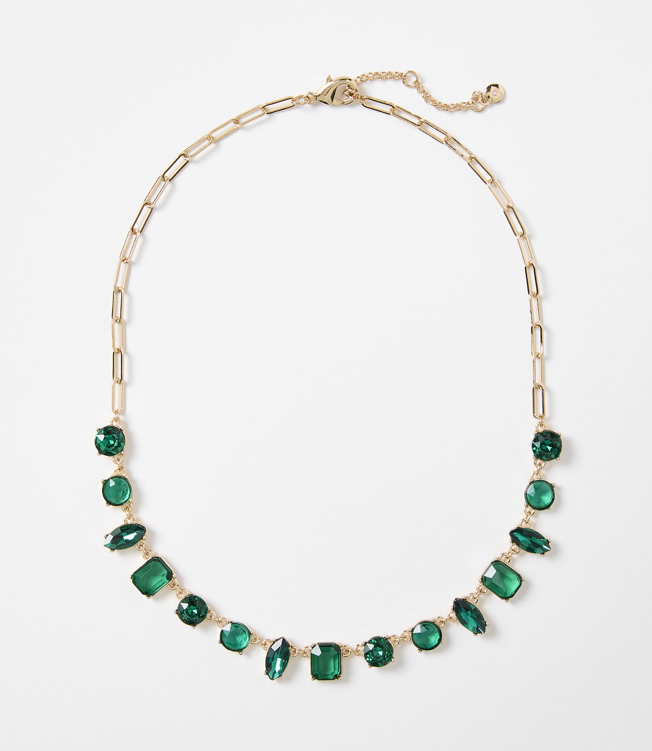 A gold chain necklace with various green gemstones is displayed against a plain white background.