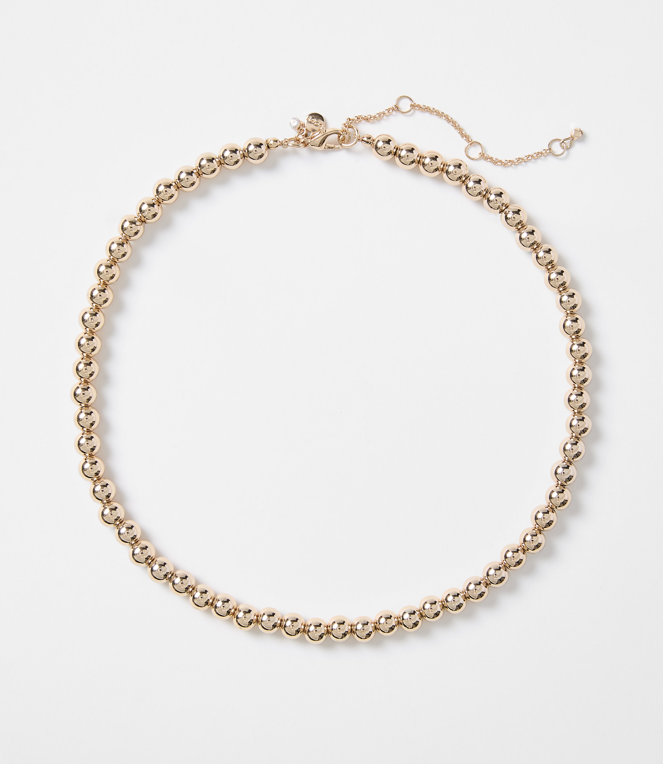 A rose gold beaded necklace with a delicate chain closure rests on a plain white background.