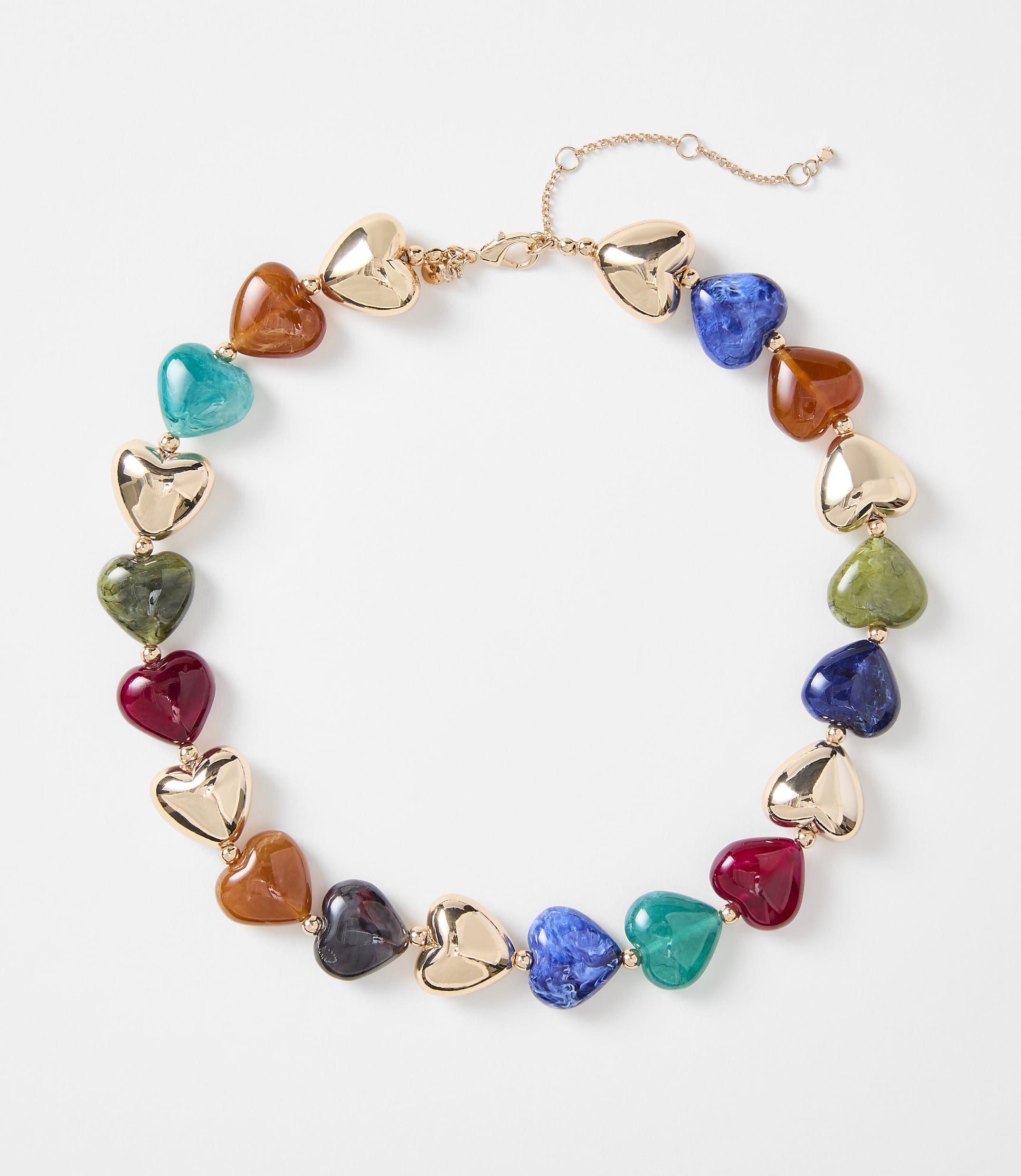 A colorful heart-shaped beaded necklace with gold accents rests on a plain white background.