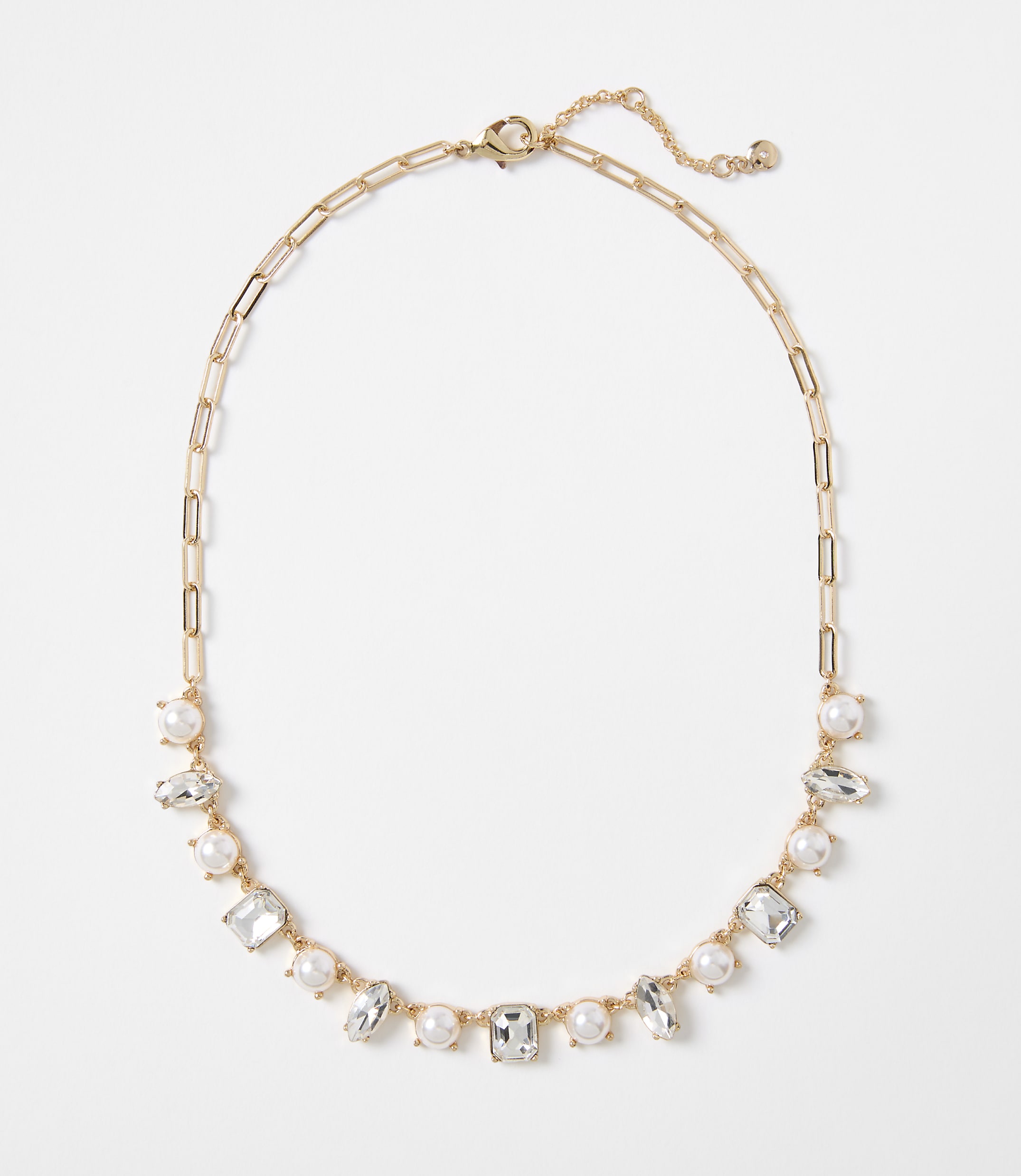 A gold chain necklace with alternating pearls and clear rectangular gems is displayed against a plain white background.