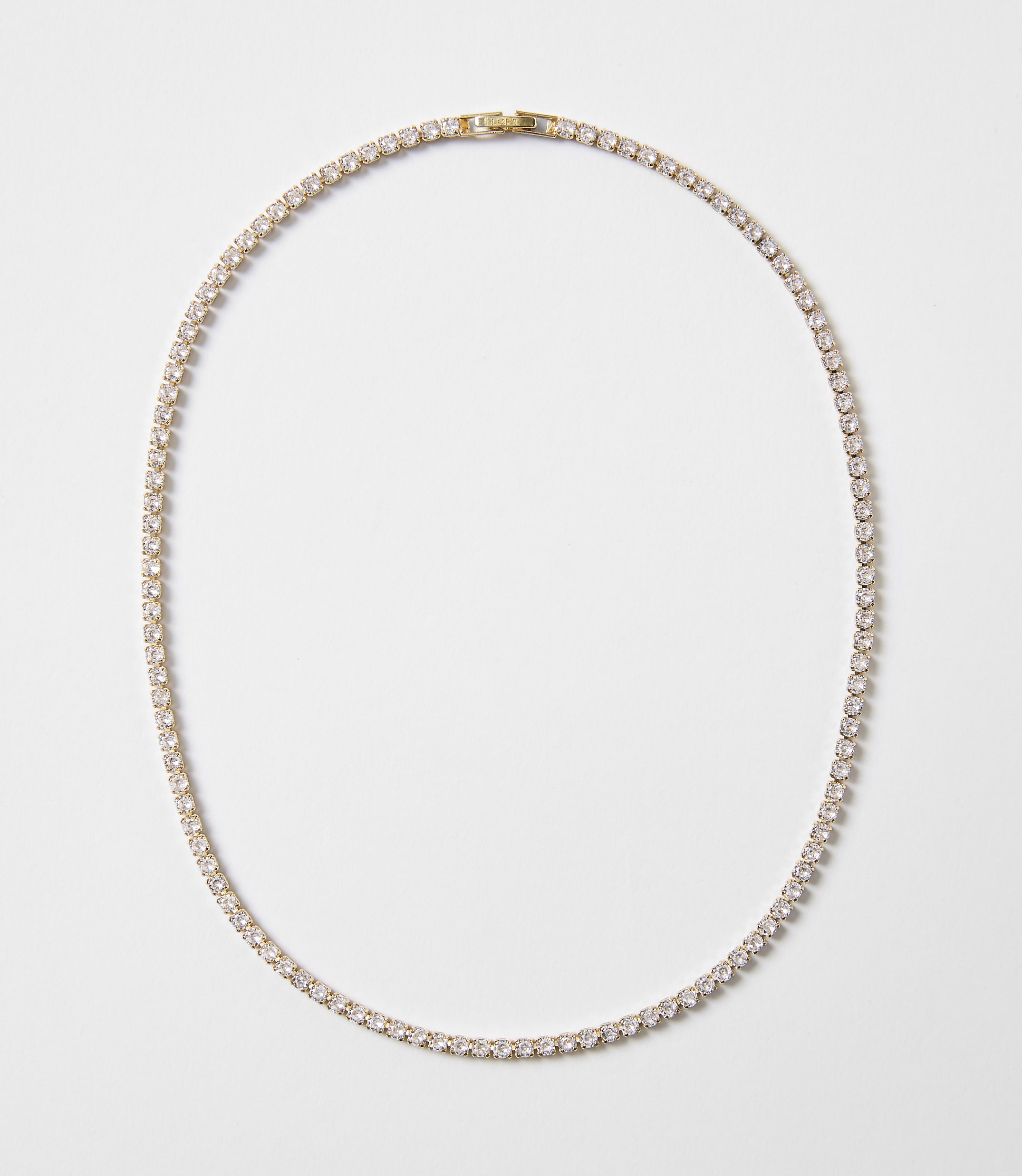 A delicate gold chain necklace with clear stones is laid out on a plain white background.