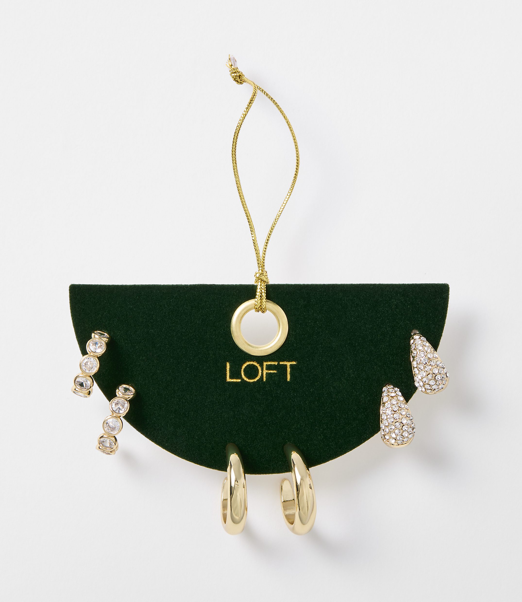 A set of gold-toned earrings, including studs and hoops, are displayed on a dark green card with the "LOFT" logo, against a plain white background.