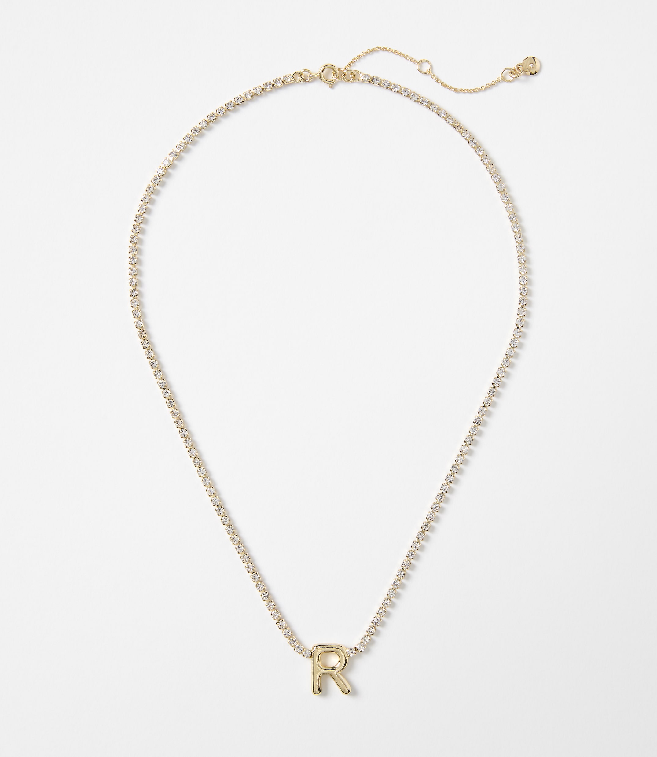 A gold letter "R" pendant on a delicate, sparkling chain rests against a plain white background.