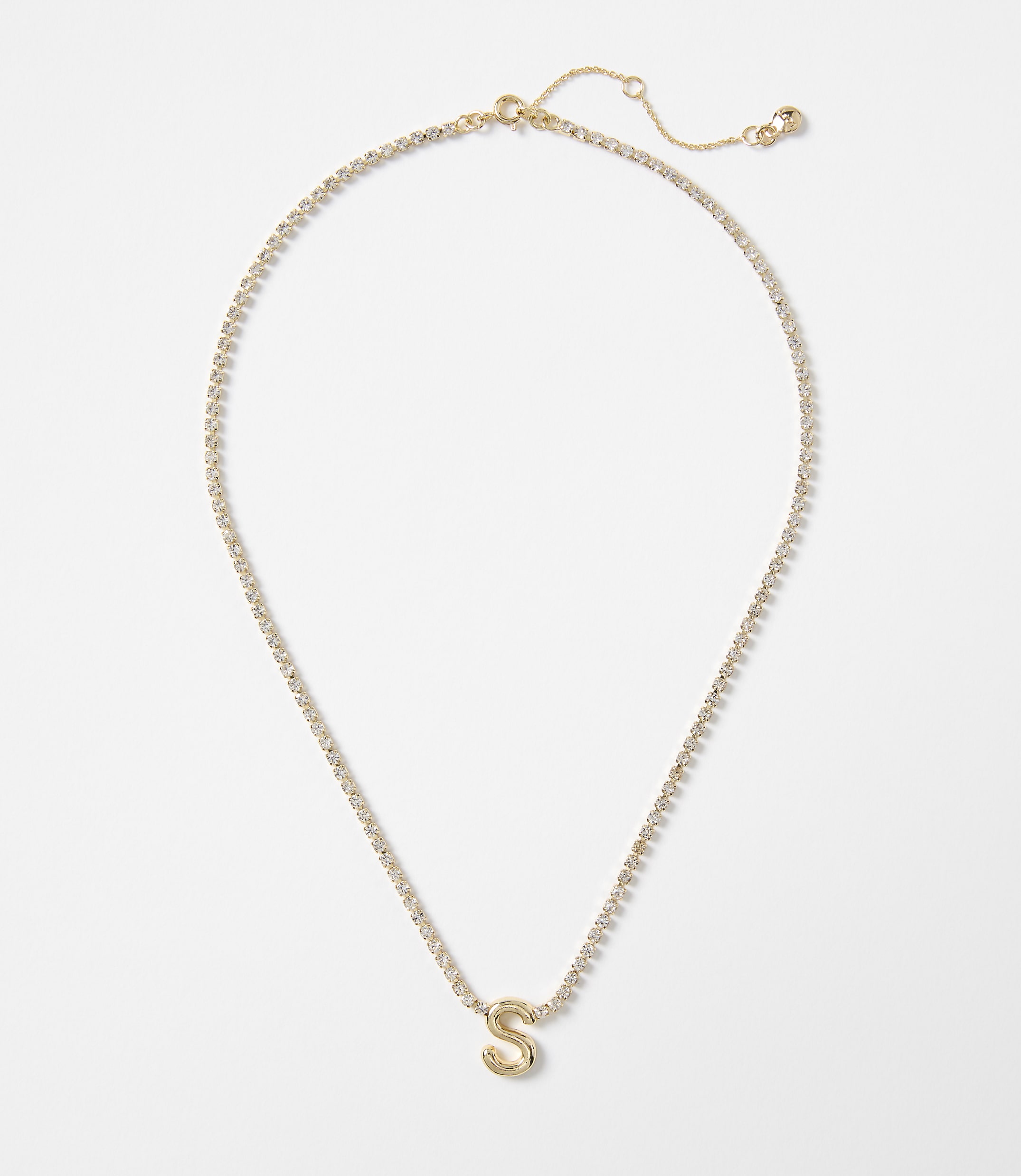 A gold letter "S" pendant hangs from a delicate, sparkling chain against a plain white background.