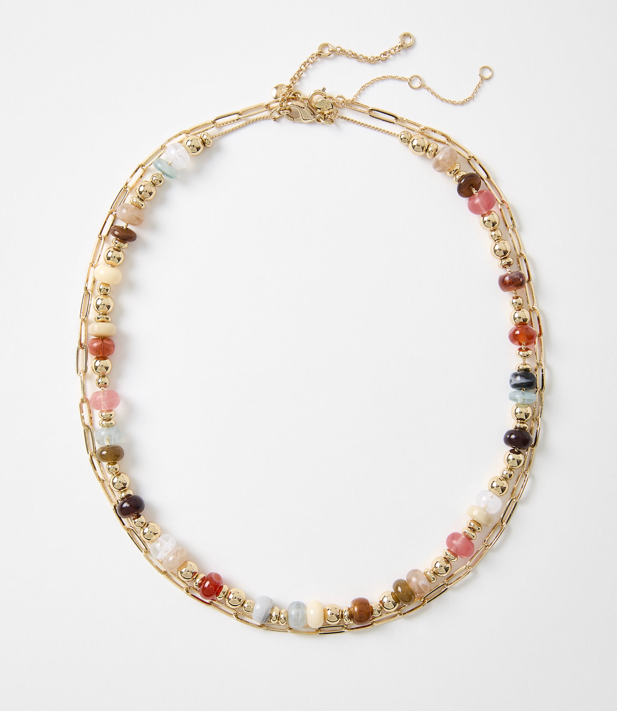 A colorful beaded necklace with gold chain accents lies on a plain white background.
