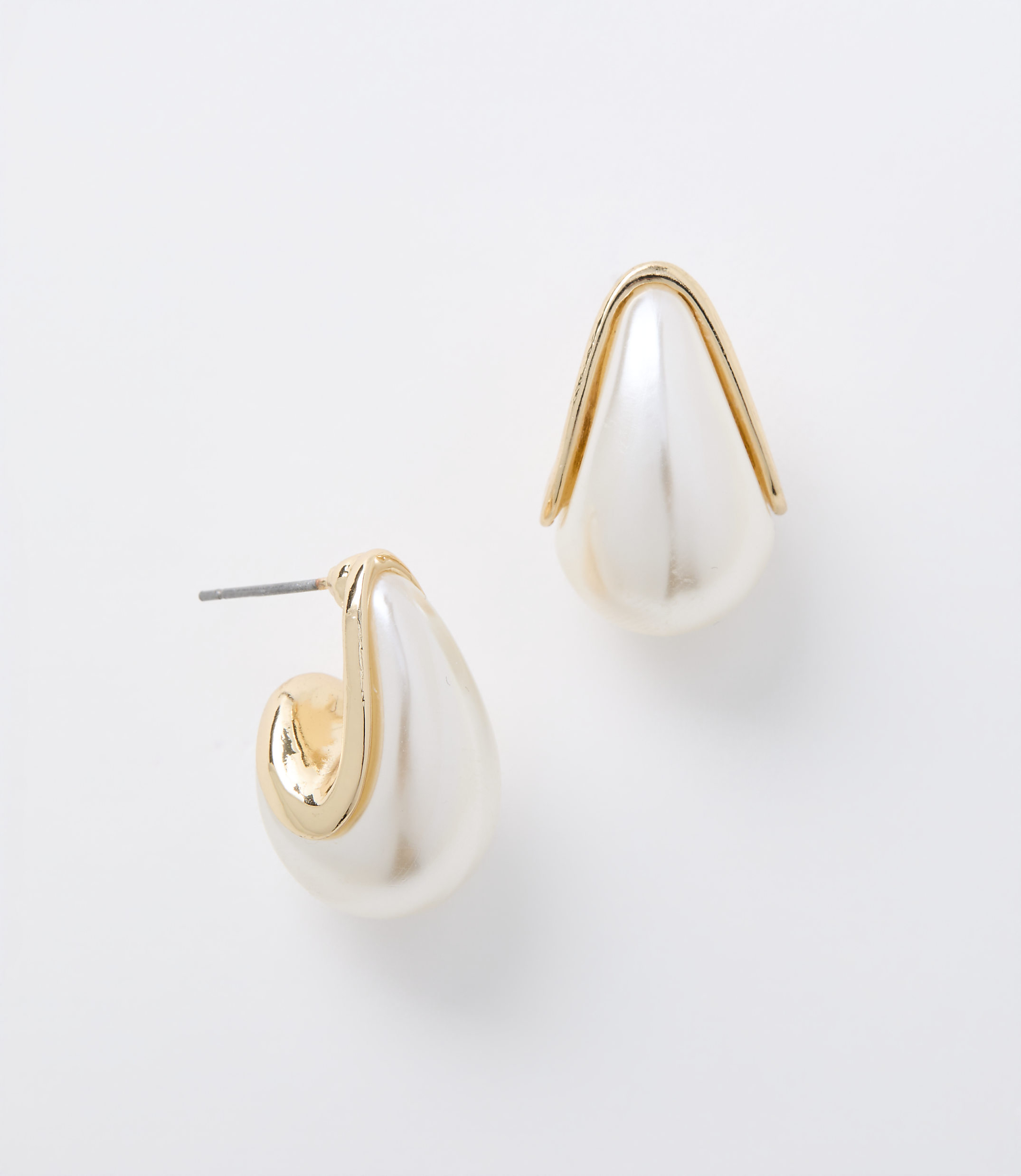 A pair of pearl and gold teardrop earrings rests on a plain white background.