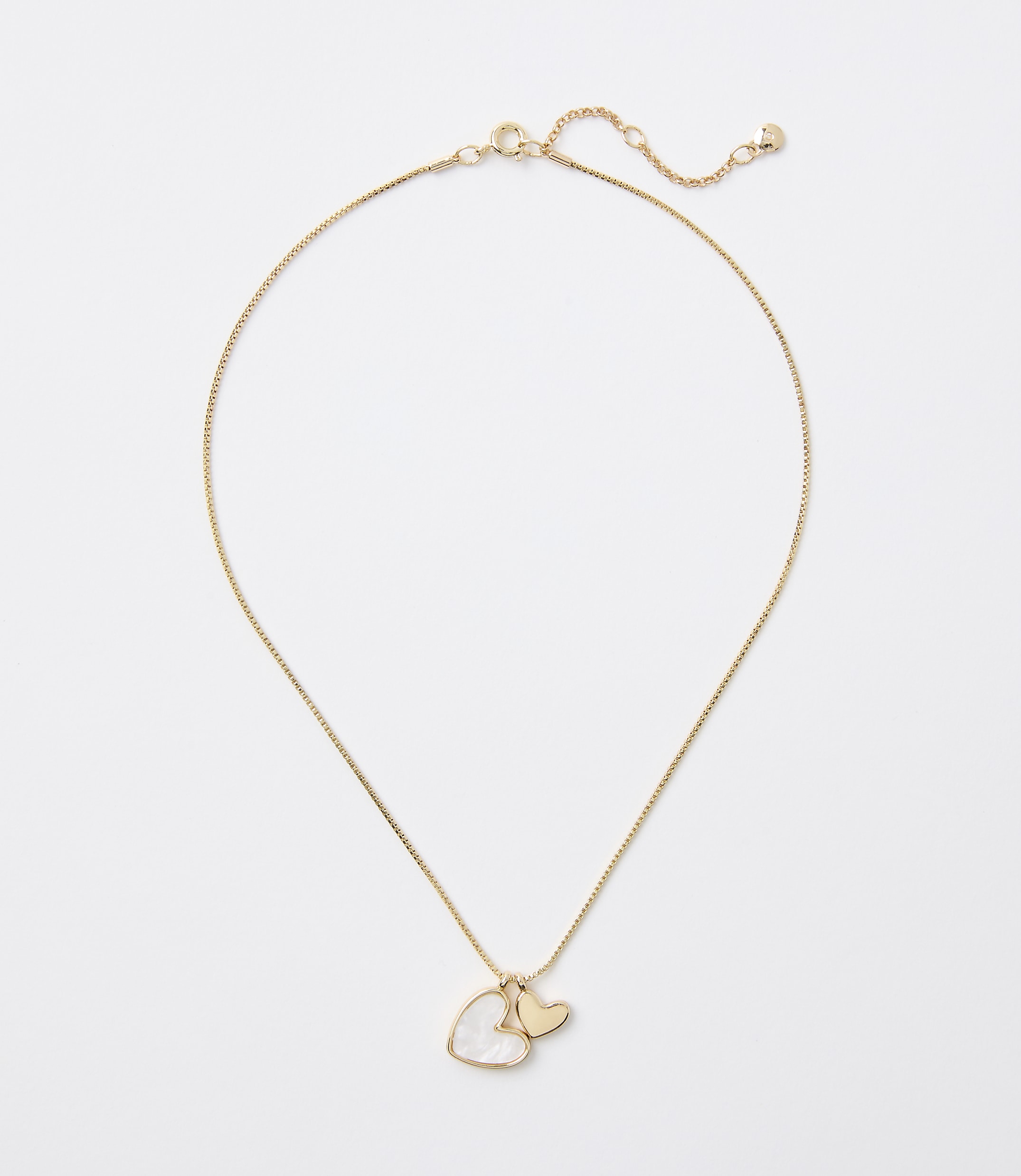 A delicate gold chain necklace with a heart-shaped pearl and a small gold heart charm hangs against a plain white background.