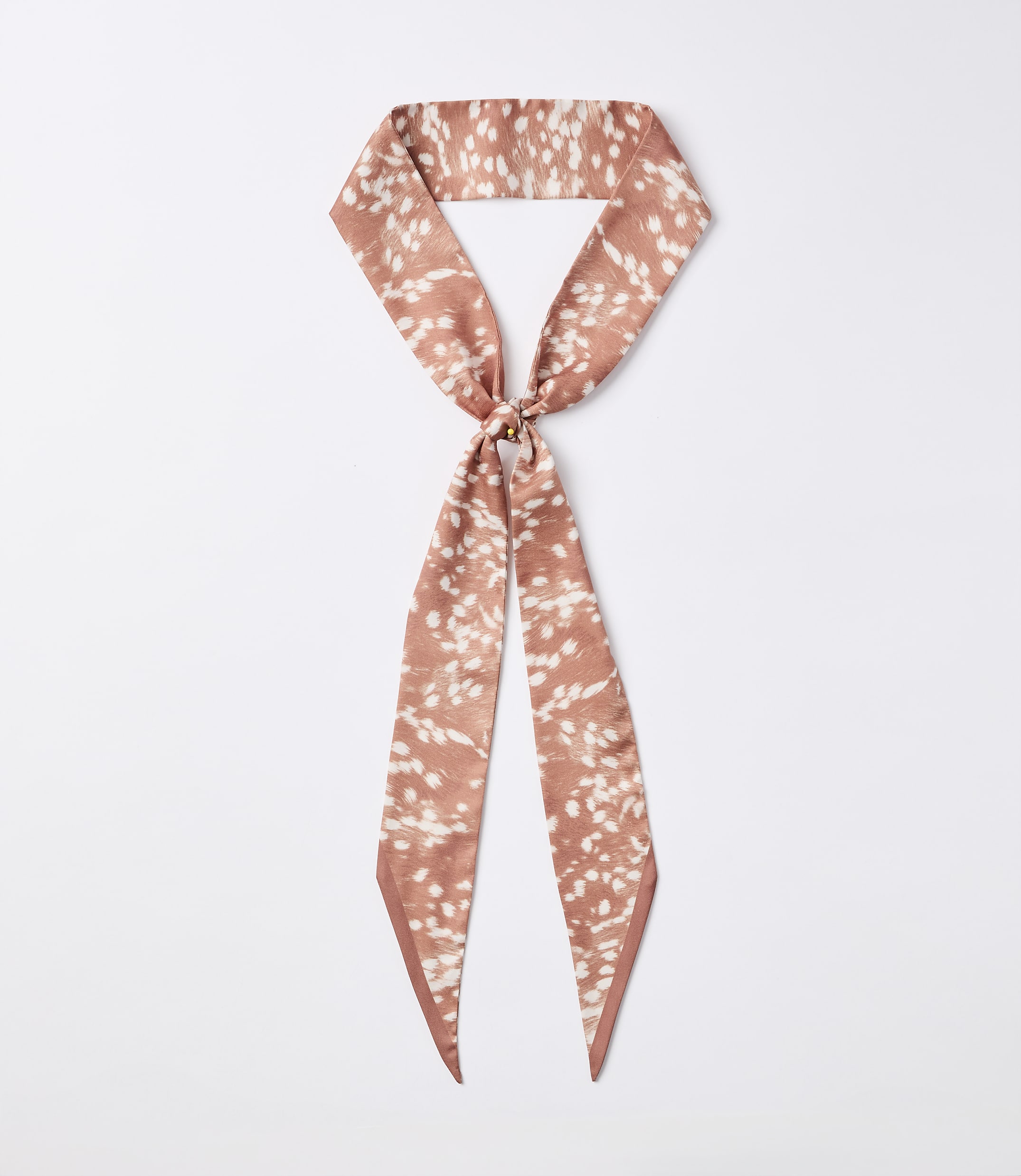 A rust-colored silky scarf with a white speckled pattern is knotted in the center, with its ends hanging down against a plain white background.