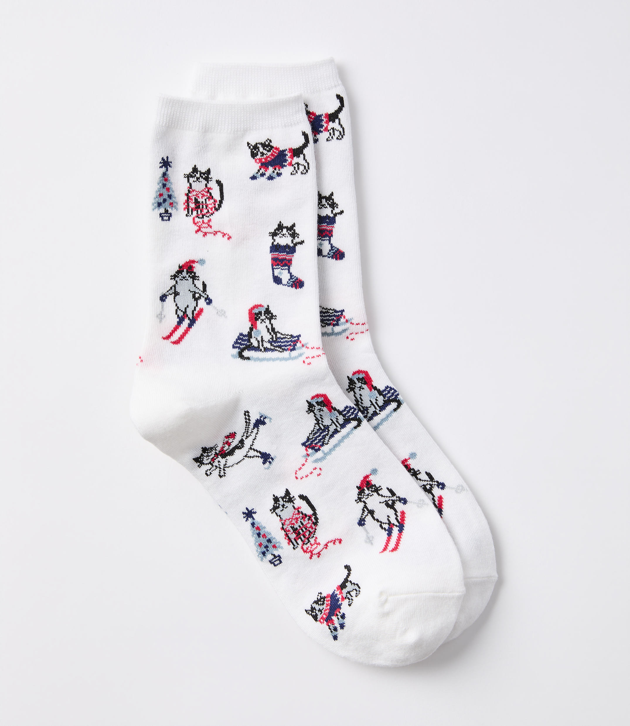 White socks with a pattern of cartoon cats in winter activities are displayed against a plain white background.