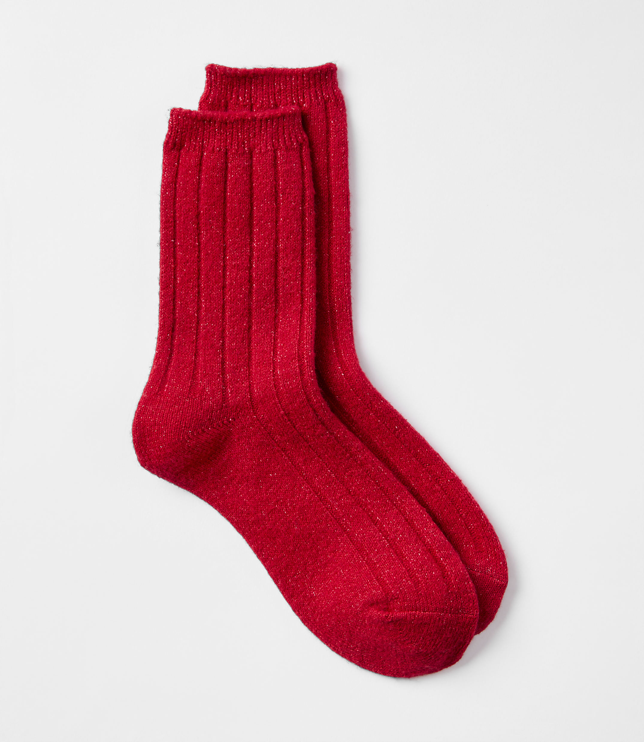 A pair of sparkly red ribbed socks rests on a plain white background.