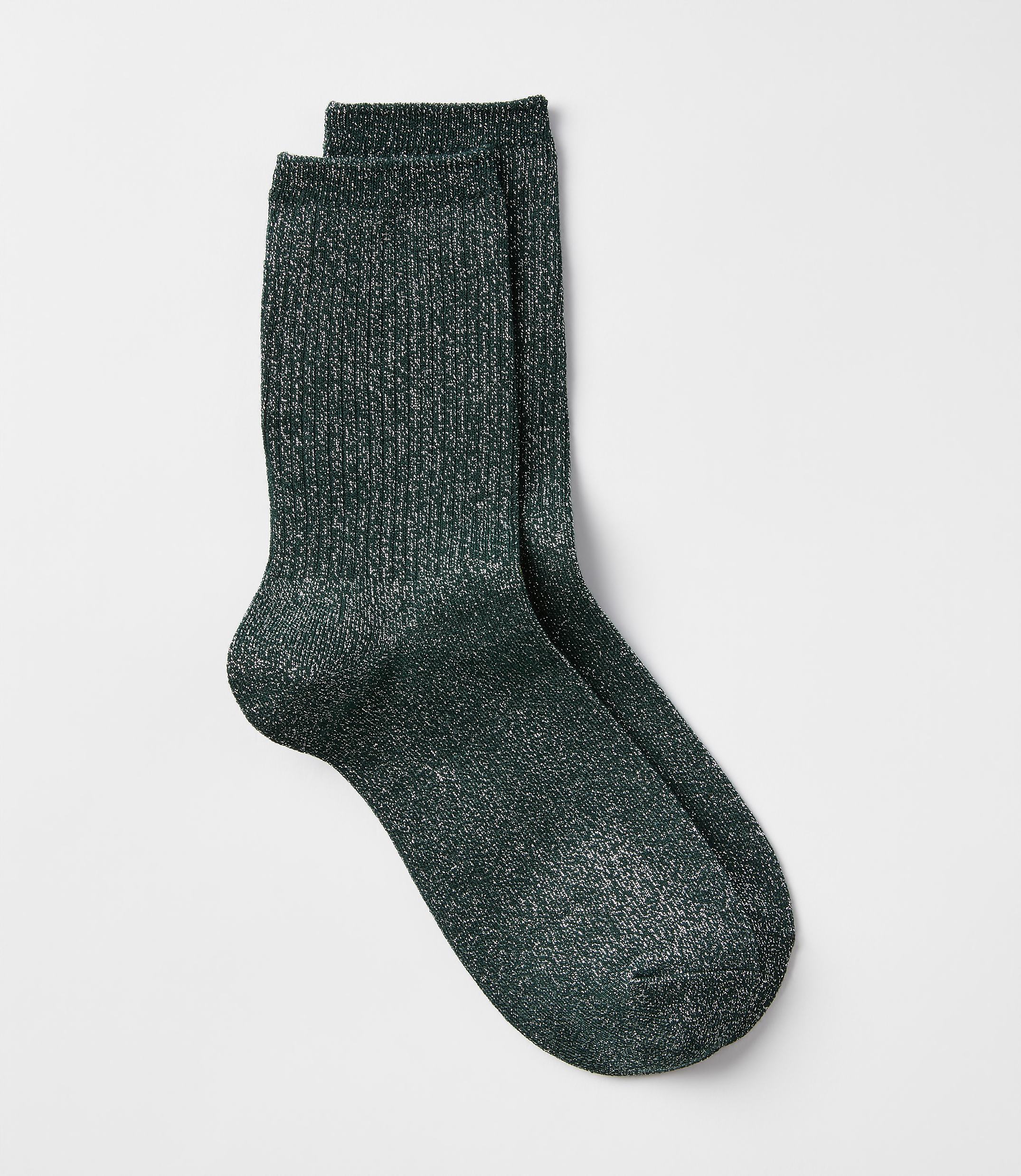 A pair of sparkly green crew socks rests on a plain white background.