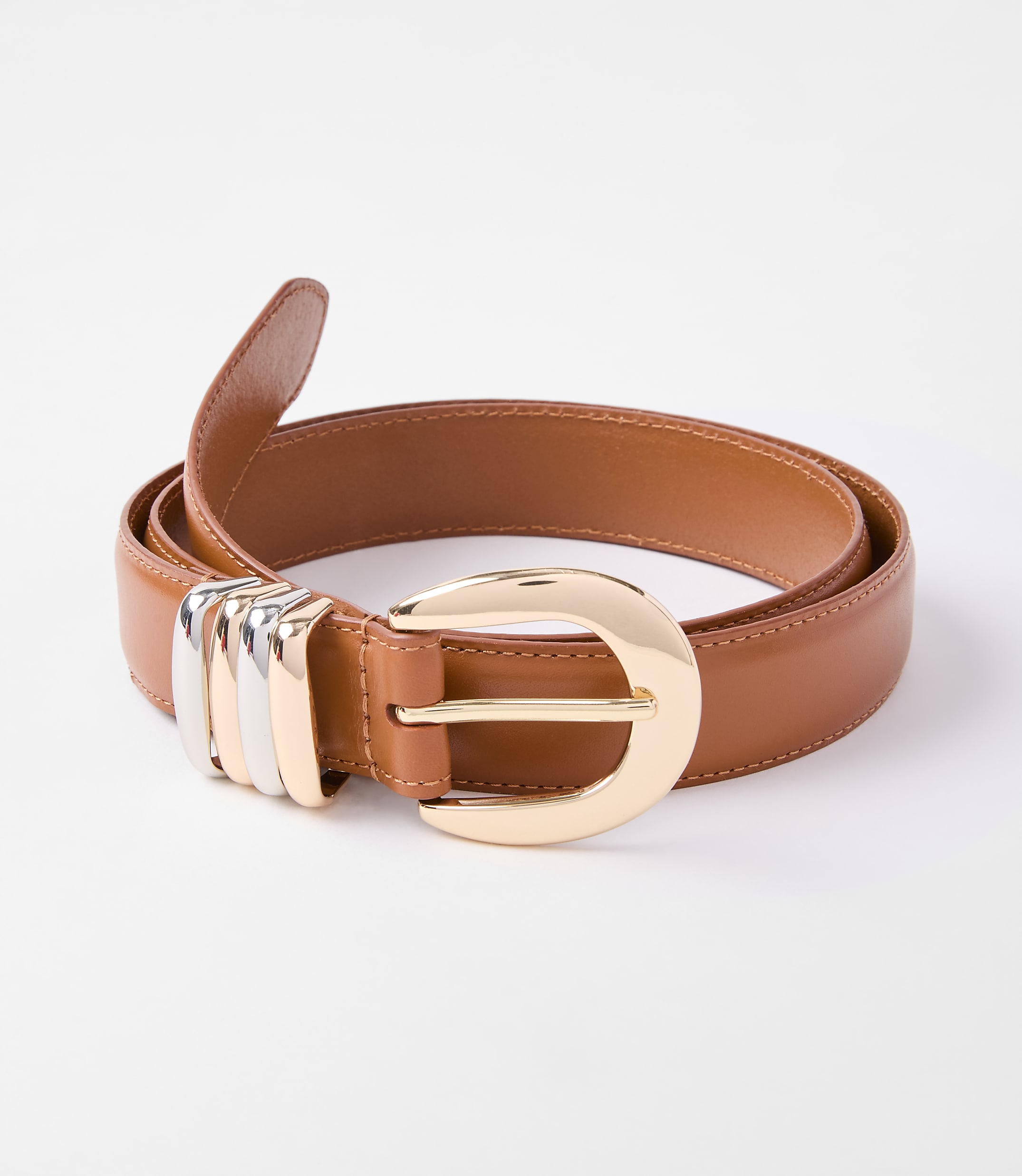 A tan leather belt with a large gold buckle and silver accents rests on a plain white background.