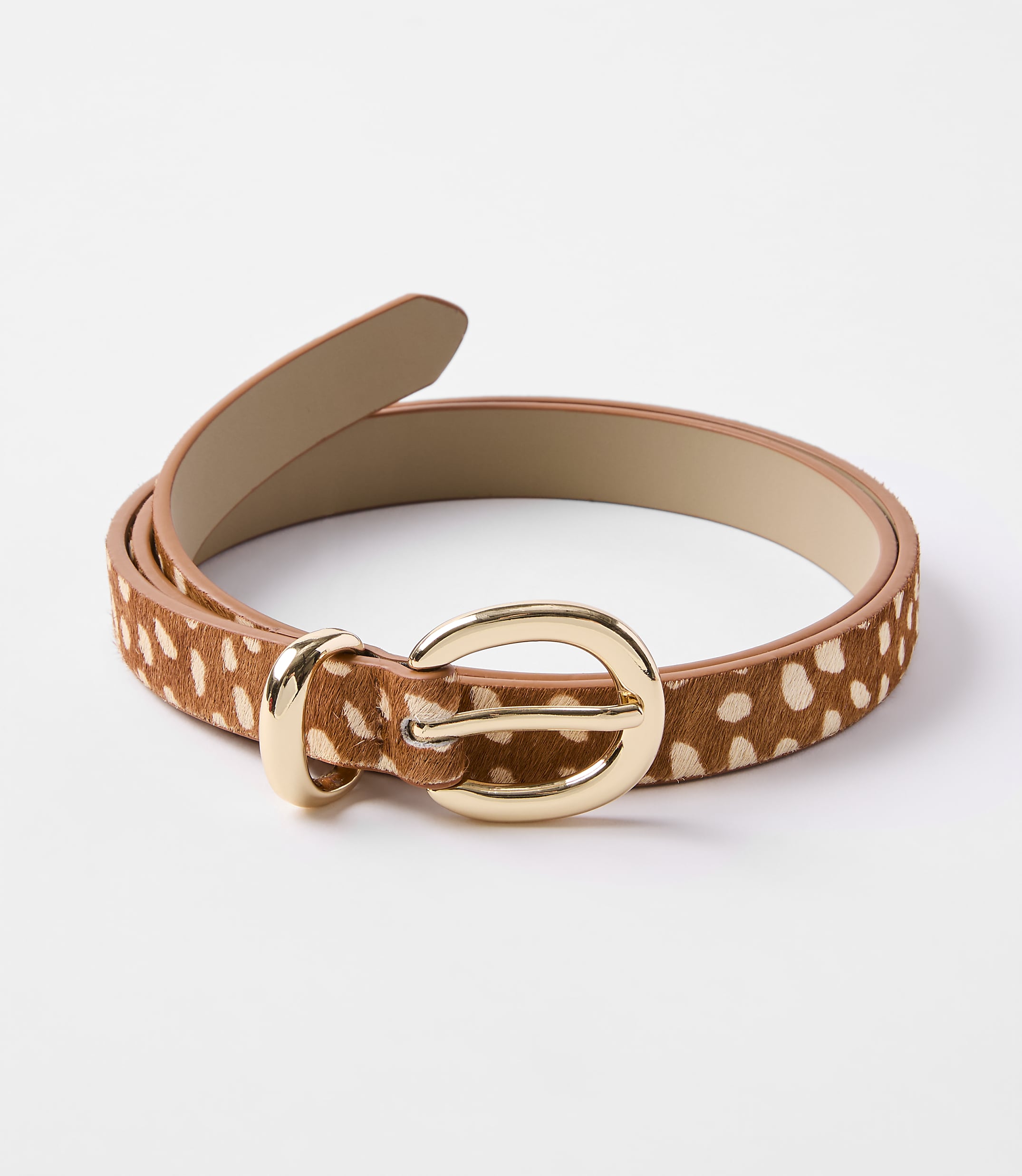 A brown and white spotted belt with a gold buckle lies on a plain white background.