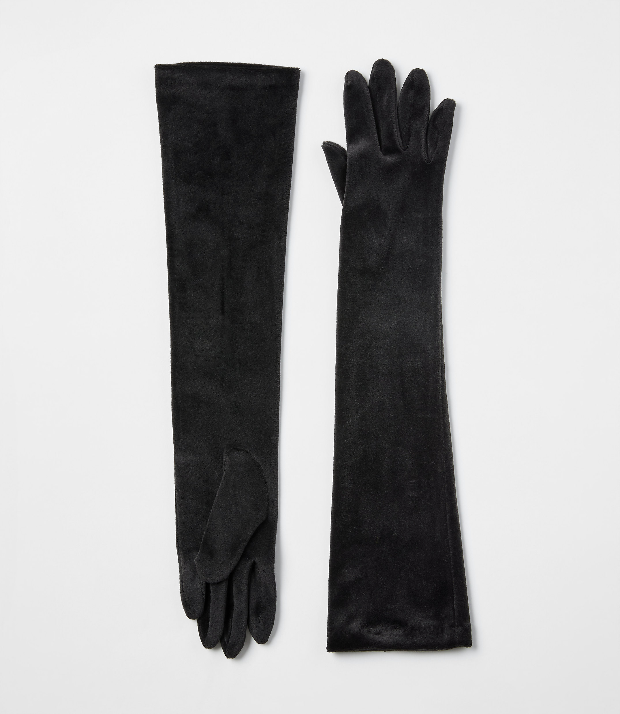 A pair of long black velvet gloves lies flat against a plain white background.