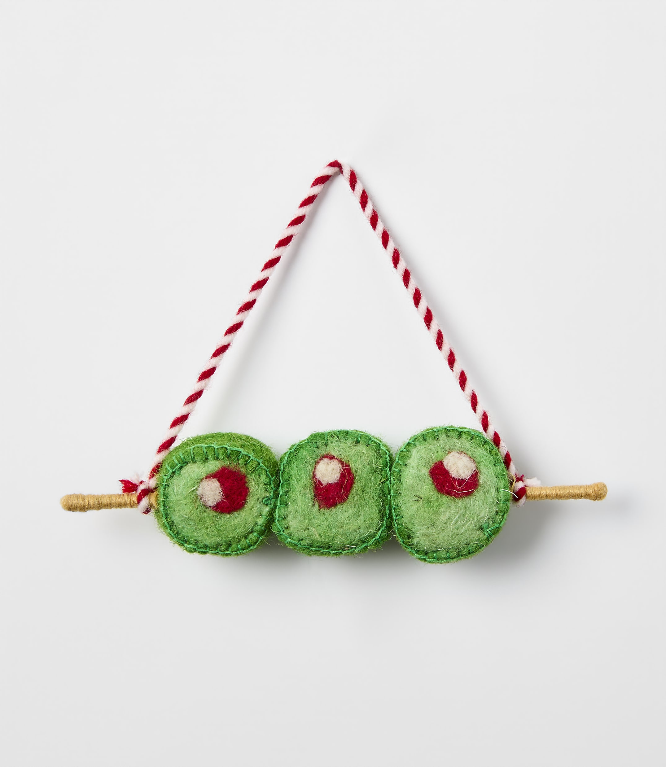 Three green felt sushi rolls on a wooden skewer with a red and white string hanger against a plain white background.