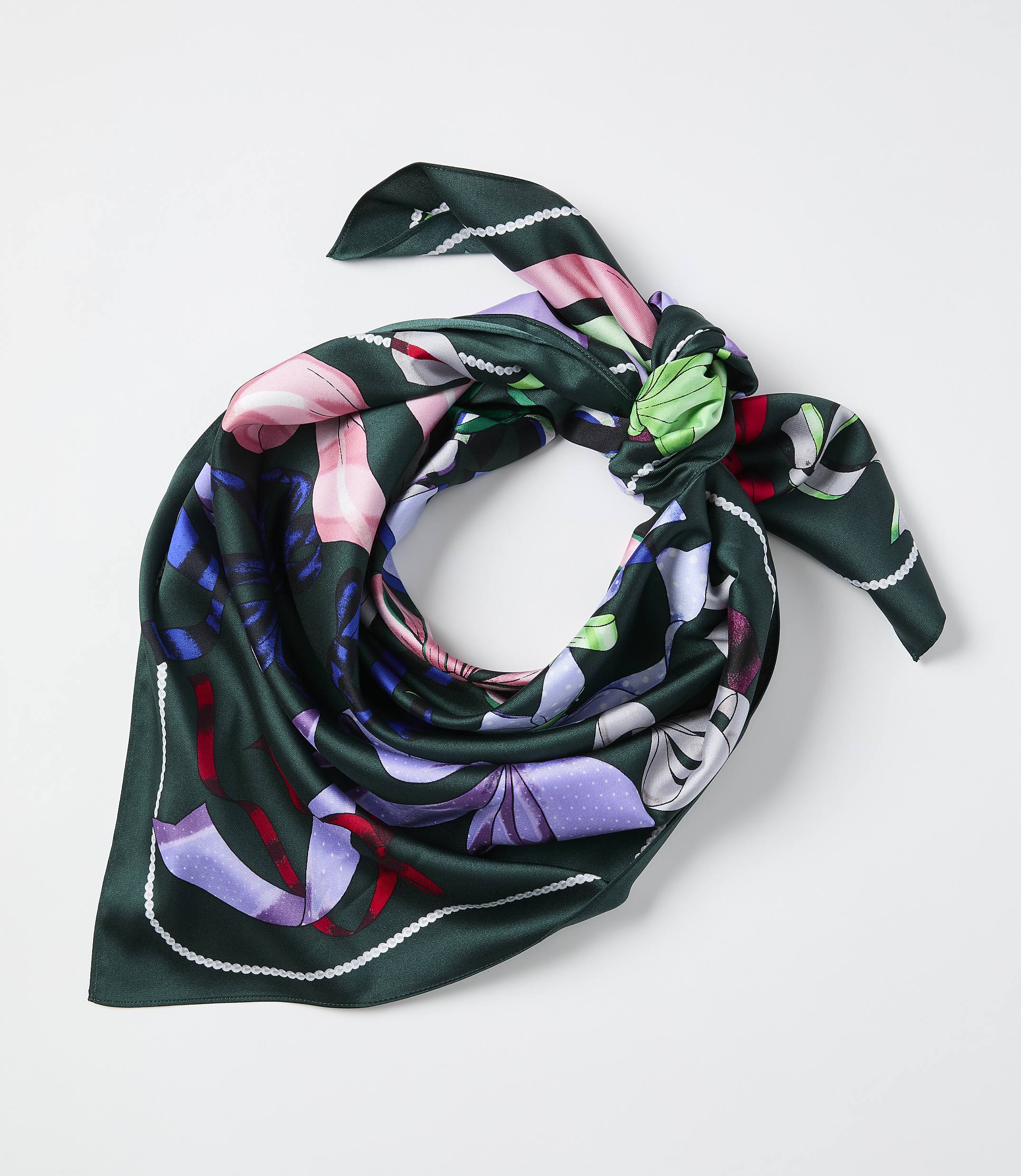 A green floral silk scarf is tied in a knot against a plain white background.