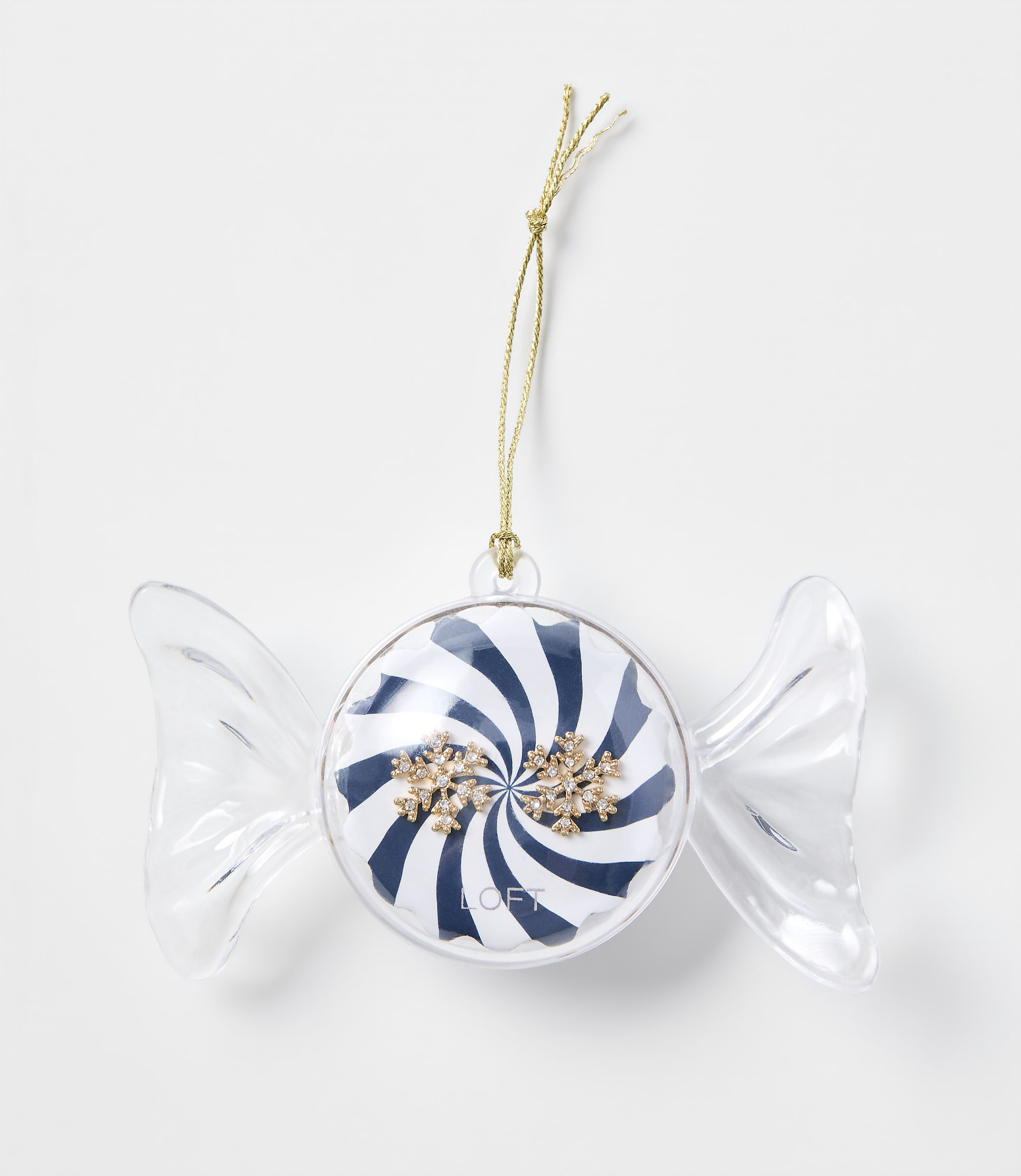 A candy-shaped Christmas ornament with blue and white stripes and gold snowflakes hangs by a gold string against a plain white background.