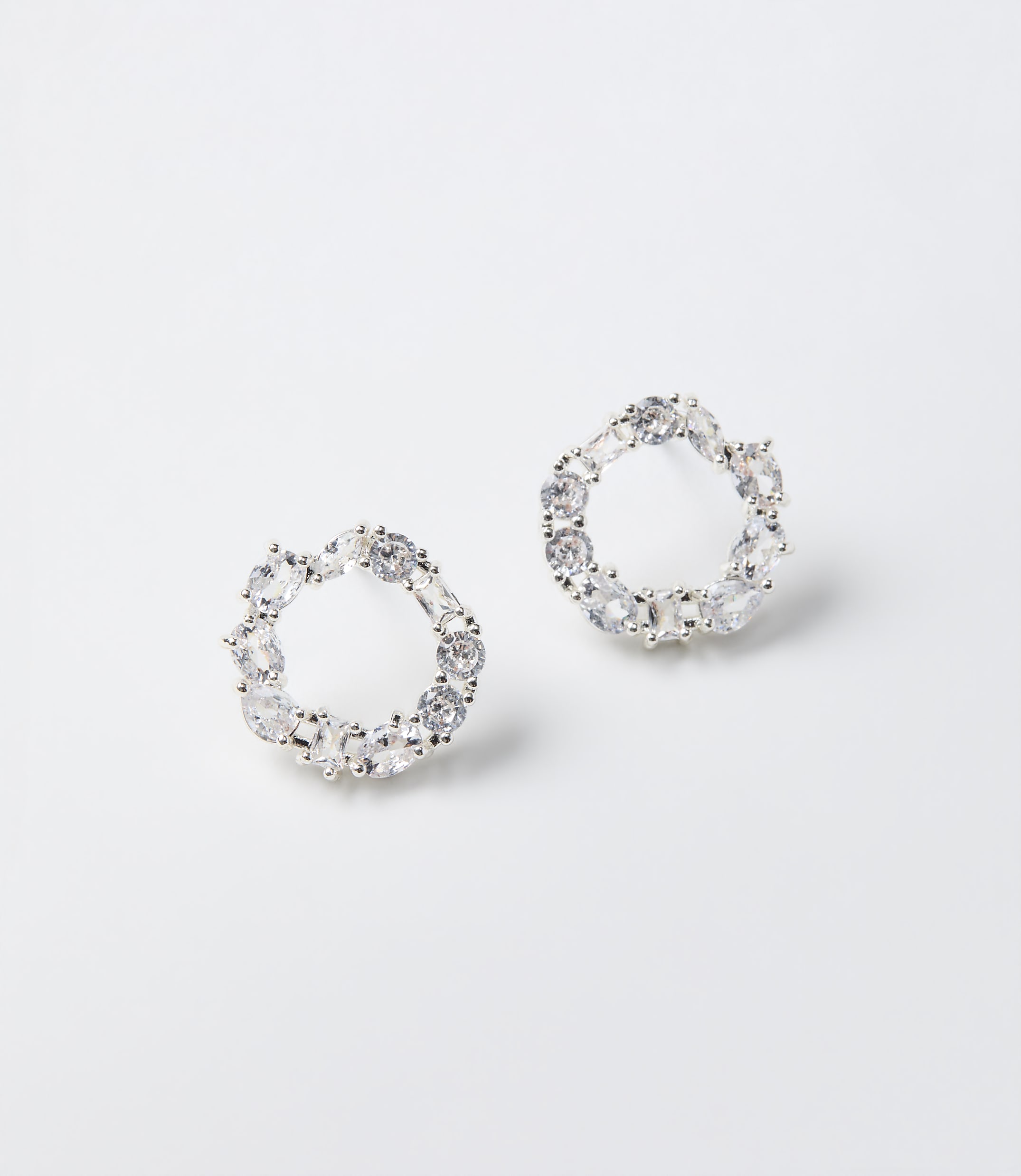 Two circular crystal earrings rest on a plain white background.