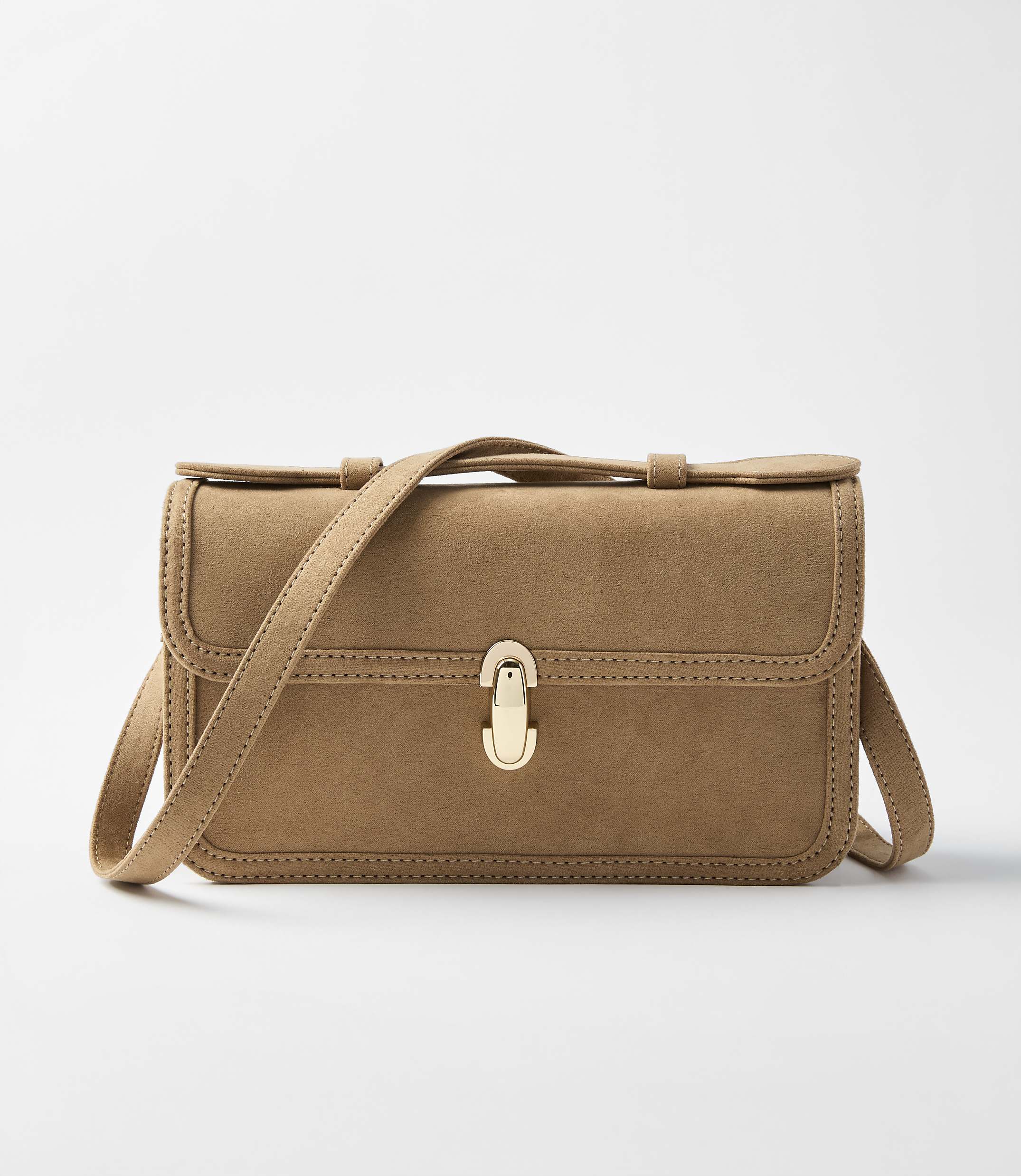 A tan suede crossbody bag with a gold clasp sits centered against a plain white background.