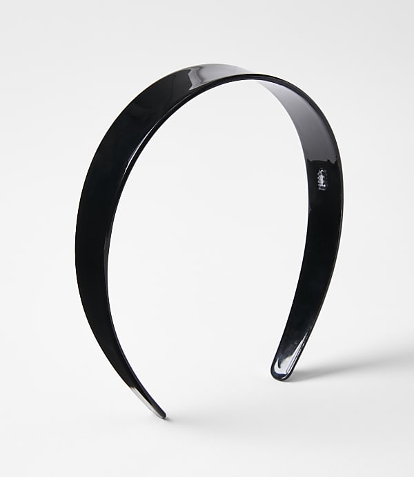 A glossy black headband rests on a plain white background.