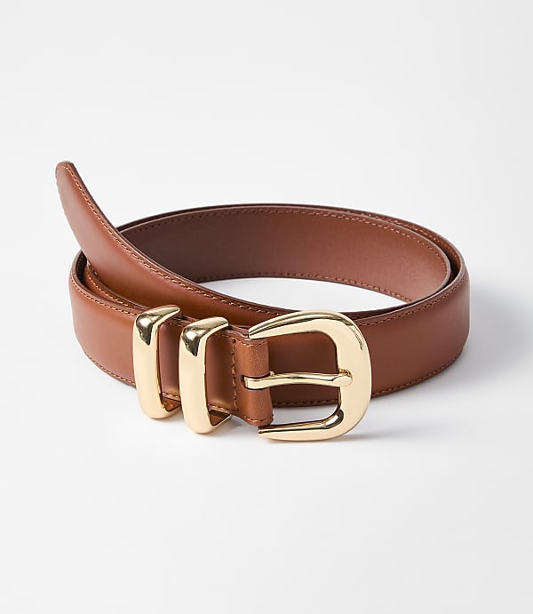 A brown leather belt with a gold buckle is laid out on a white background.