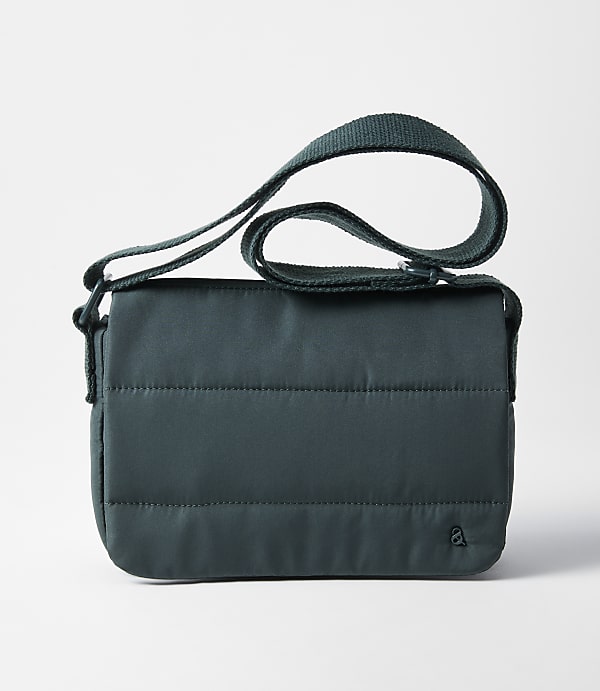 A dark teal quilted crossbody bag with a green strap rests on a plain white background.