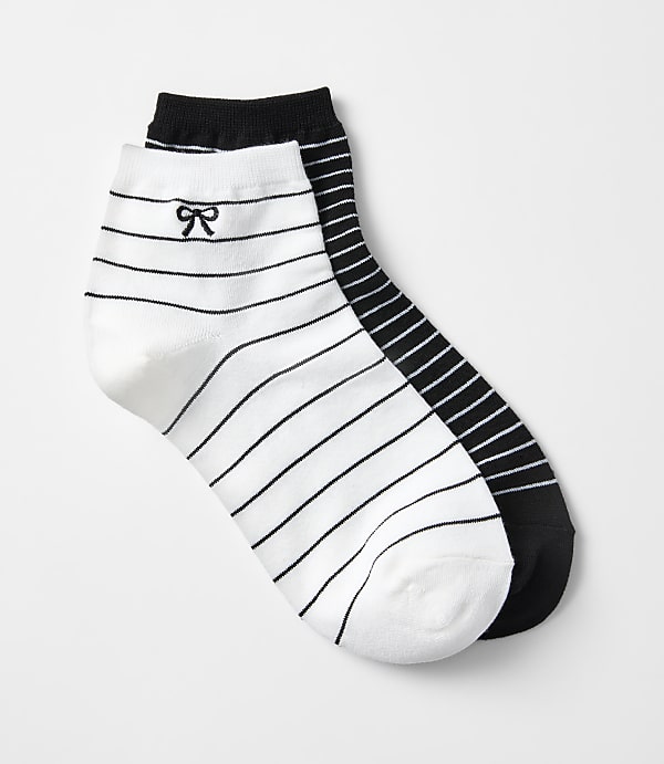 Two striped ankle socks, one white with a black bow and the other black, are laid out against a plain white background.