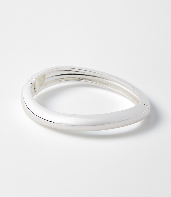 A sleek, silver bangle rests on a plain white background.
