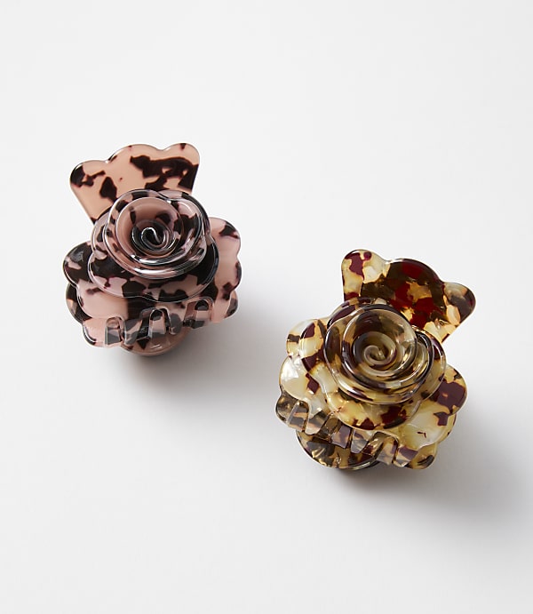 Two rose-shaped hair clips with marbled patterns sit on a plain white background.