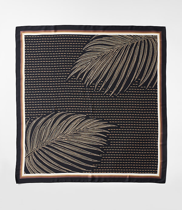 A dark square scarf with a pattern of two tan palm fronds against a background of horizontal dashed lines is bordered by thin stripes of white, brown, and black.