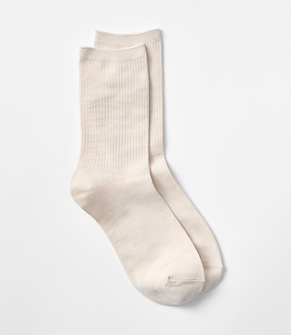 A pair of cream-colored ribbed socks rests on a plain white background.