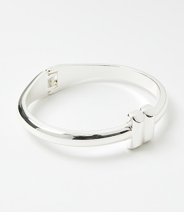 A silver bracelet with a modern design sits on a plain white background.