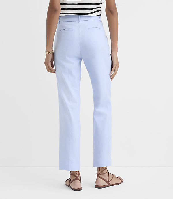 A person wearing light blue pants and brown sandals stands against a plain white background.