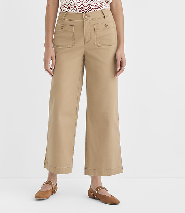 A person stands in tan wide-leg pants with large front pockets and brown flats, against a plain white background.