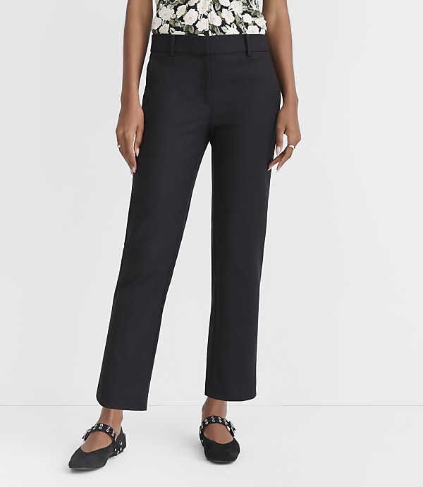 A person stands in black pants and flats against a plain white background.