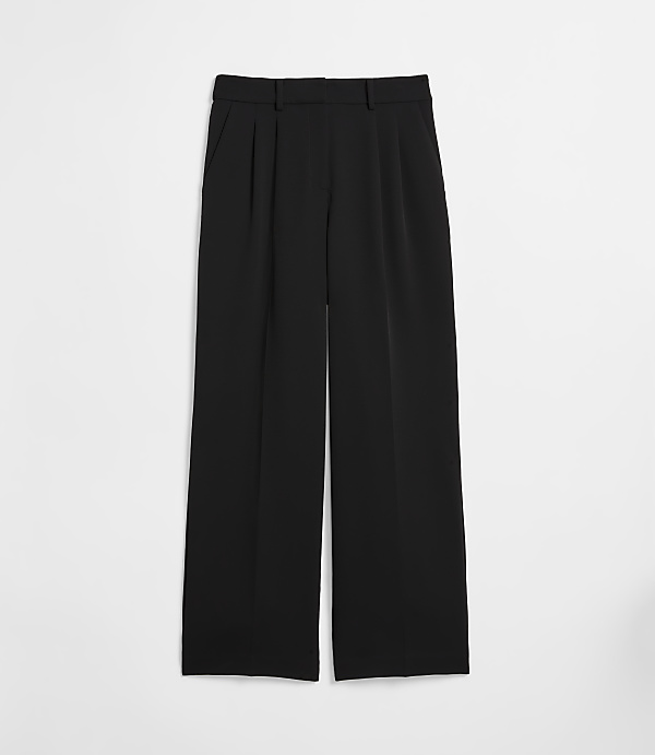 Black wide-leg trousers with pleats in the foreground are set against a plain white background.
